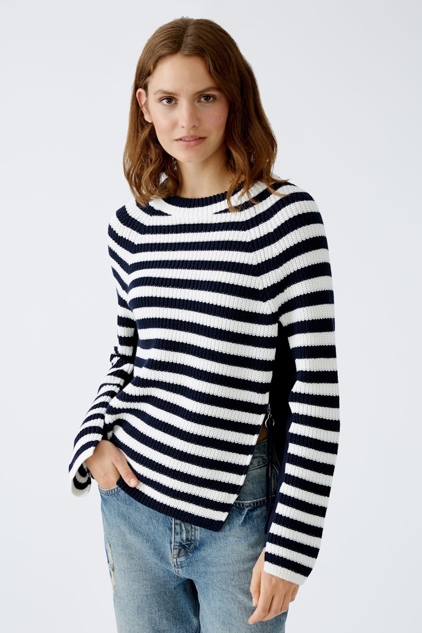 Stylish women's pullover: A woman in a navy and white striped pullover paired with casual jeans.