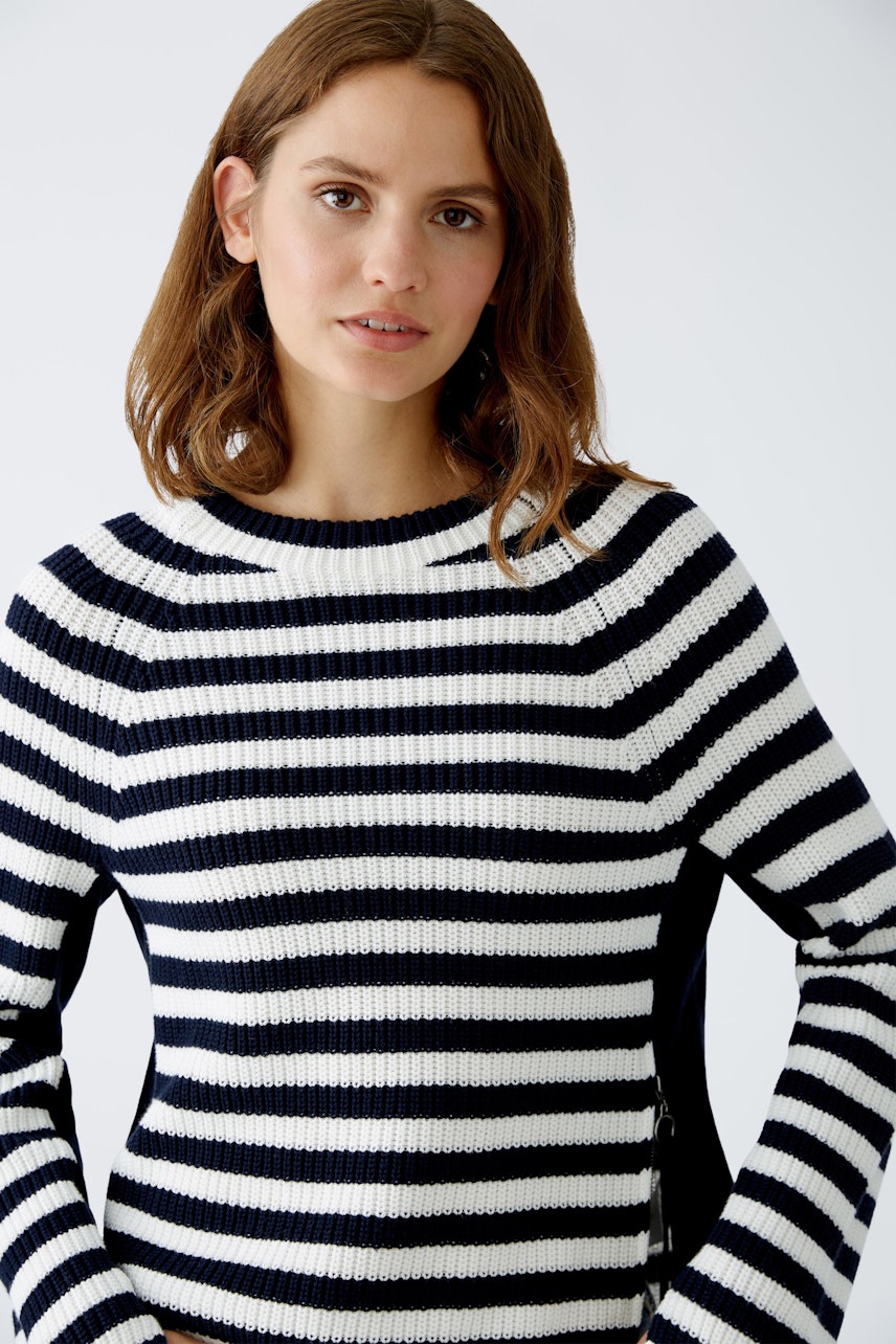 Modern women's pullover: A woman in a striped navy and white pullover, exuding casual elegance.