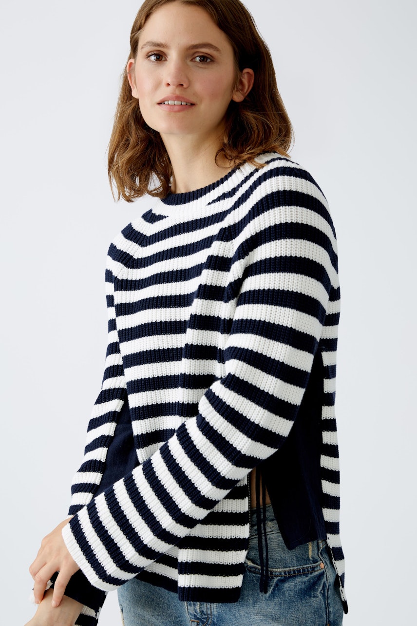 Modern women's pullover: A woman in a striped navy and white pullover with a relaxed fit.