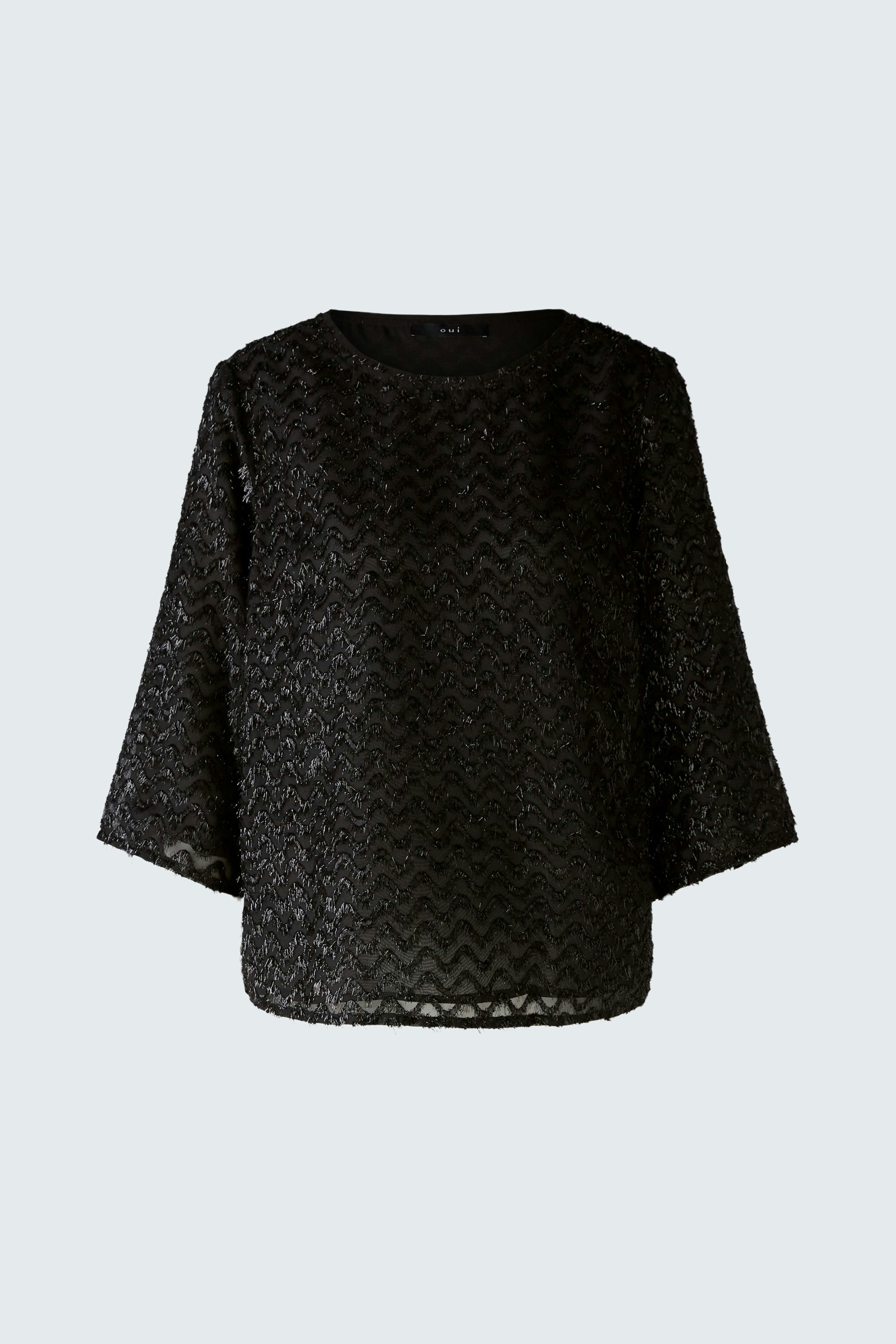 Elegant black pullover: A woman in a textured black pullover with wide sleeves exudes sophistication.