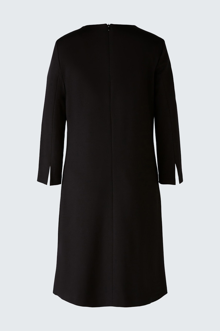 Elegant A-line dress: A woman in a sleek black dress with three-quarter sleeves, showcasing a timeless silhouette.