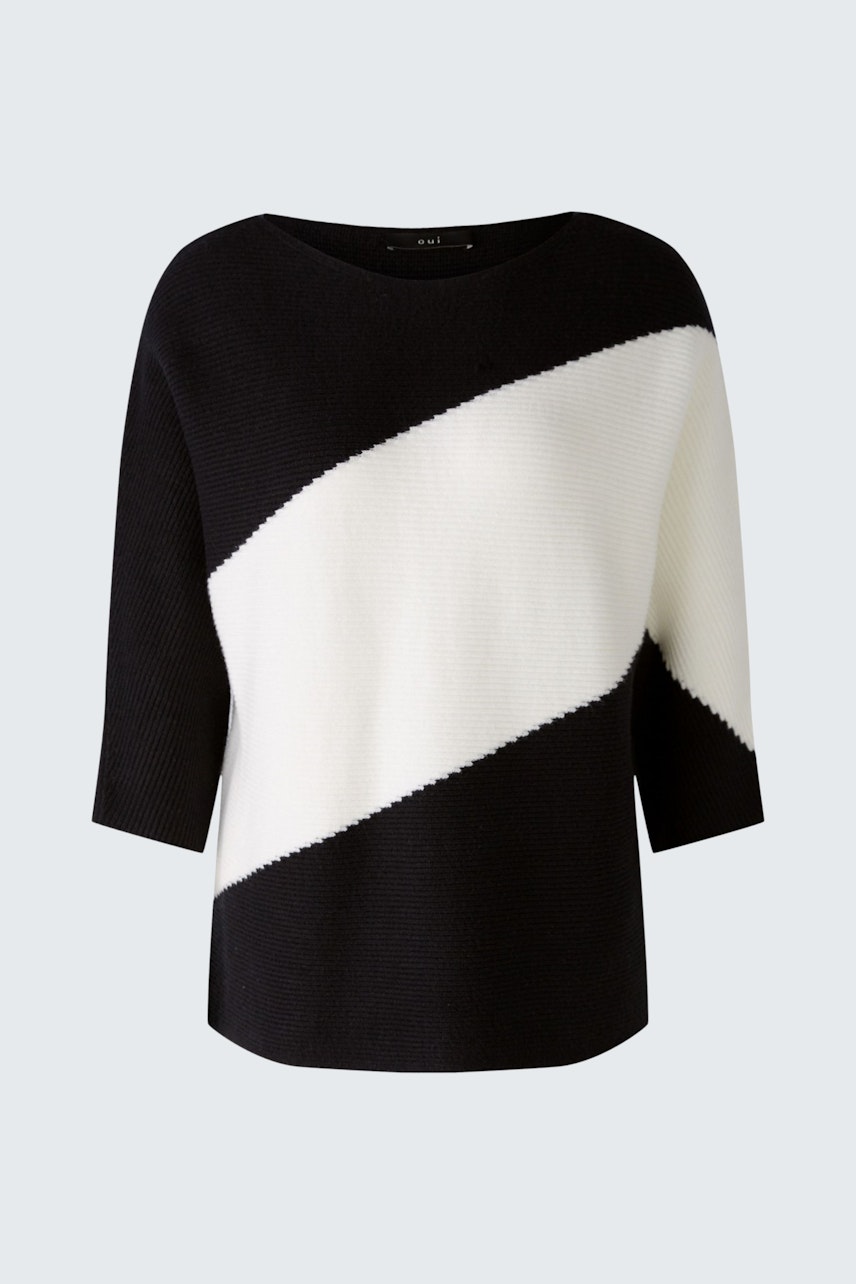 Stylish women's pullover: A woman in a black and white striped pullover, exuding confidence.