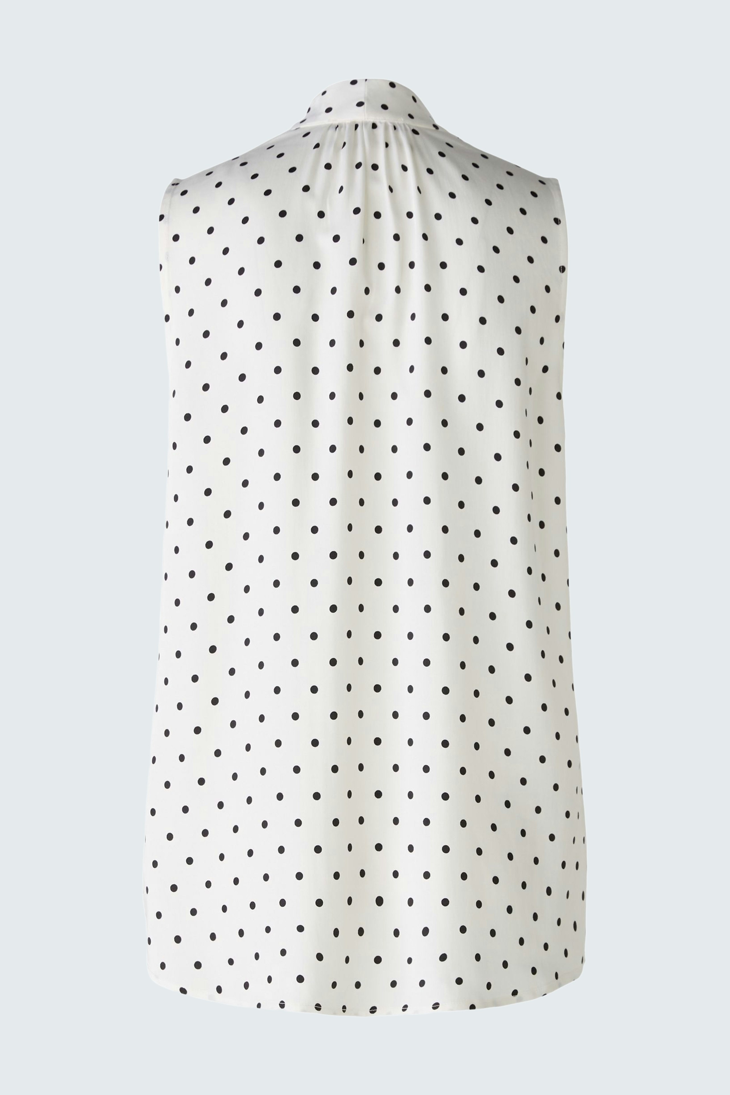 Elegant women's blouse: A sleeveless white blouse with black polka dots, perfect for any occasion.