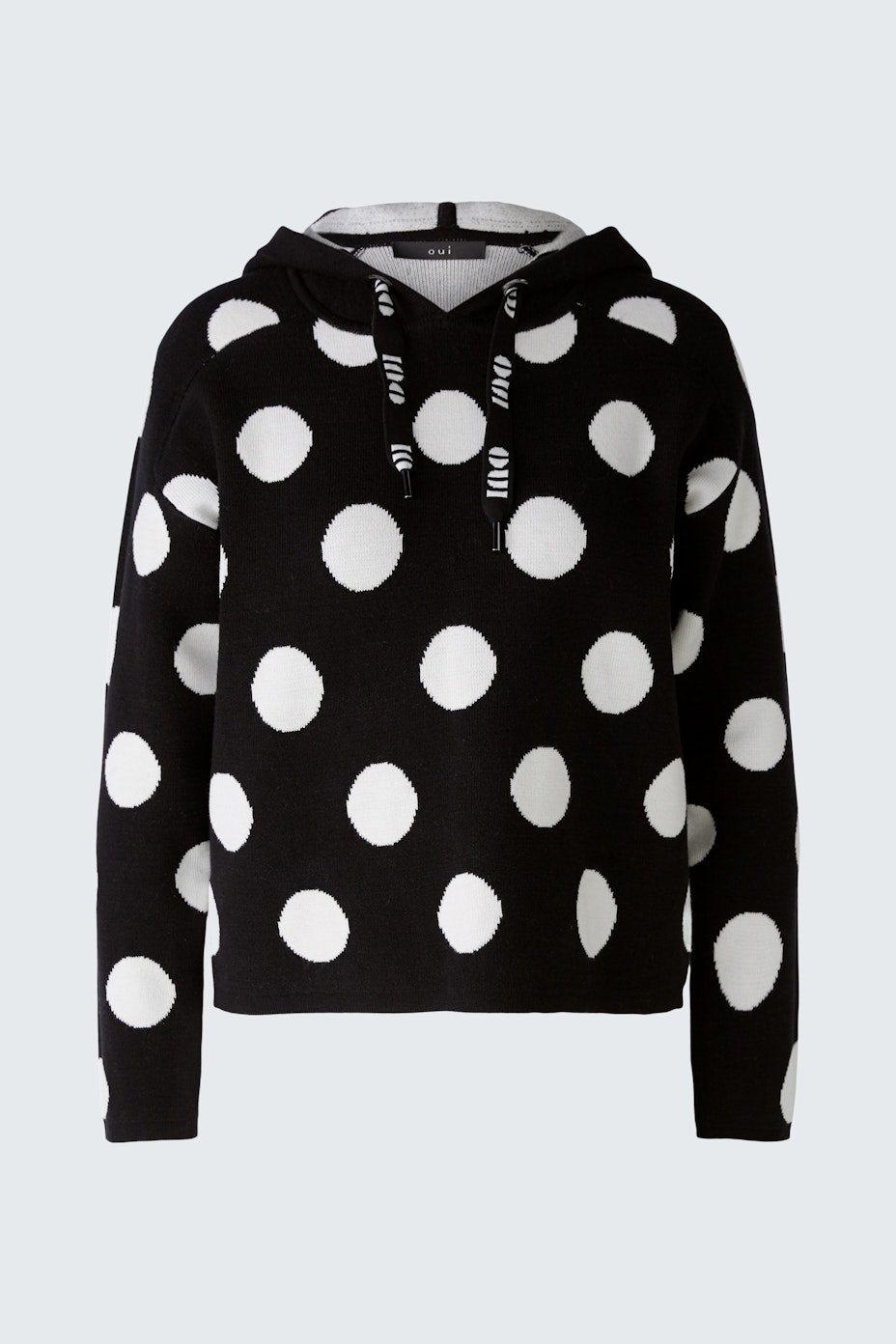 Stylish women's hoodie: Black pullover with white polka dots, perfect for casual wear.