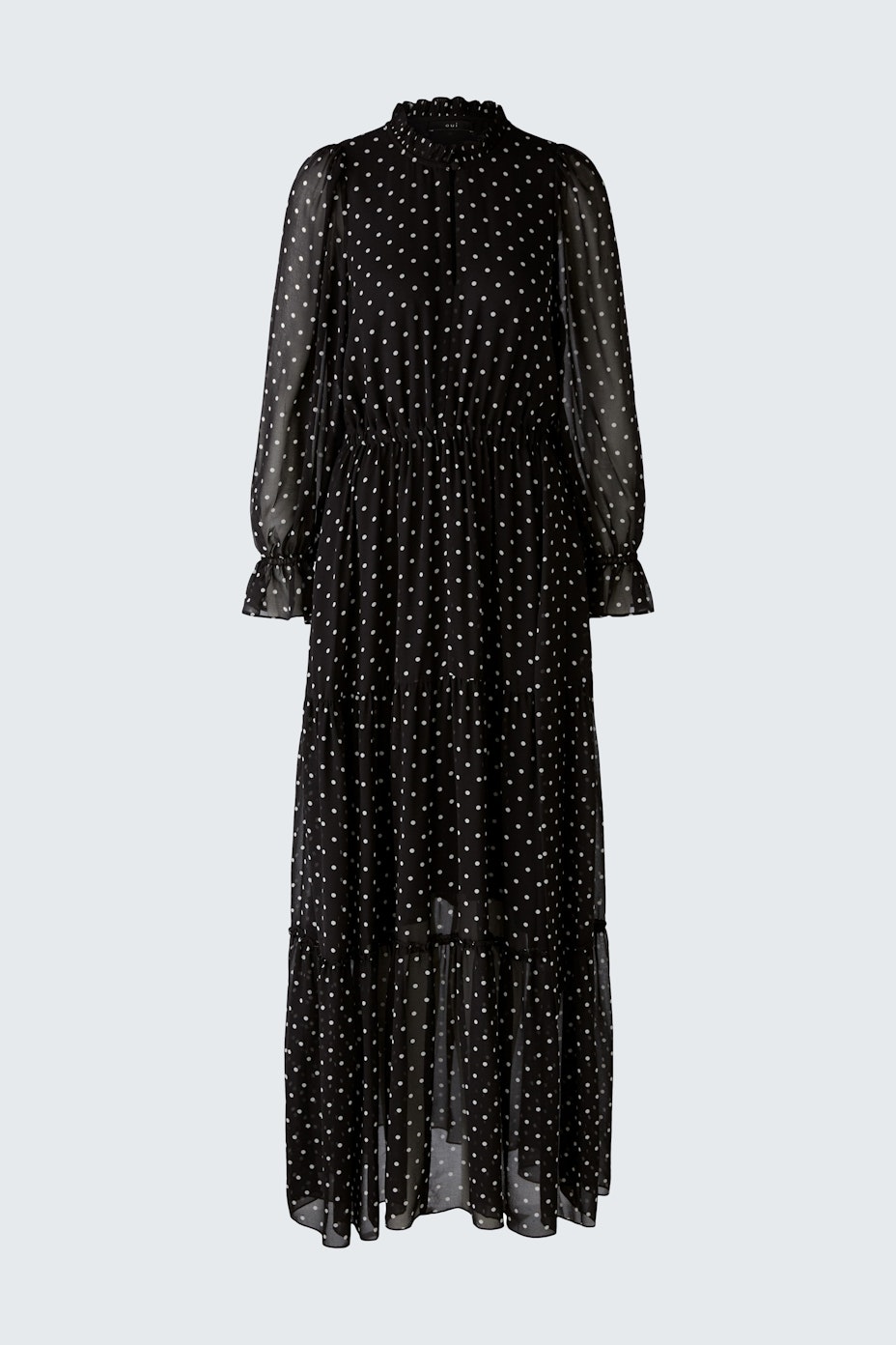 Elegant evening dress: A woman in a black polka dot maxi dress with sheer sleeves, perfect for special occasions.