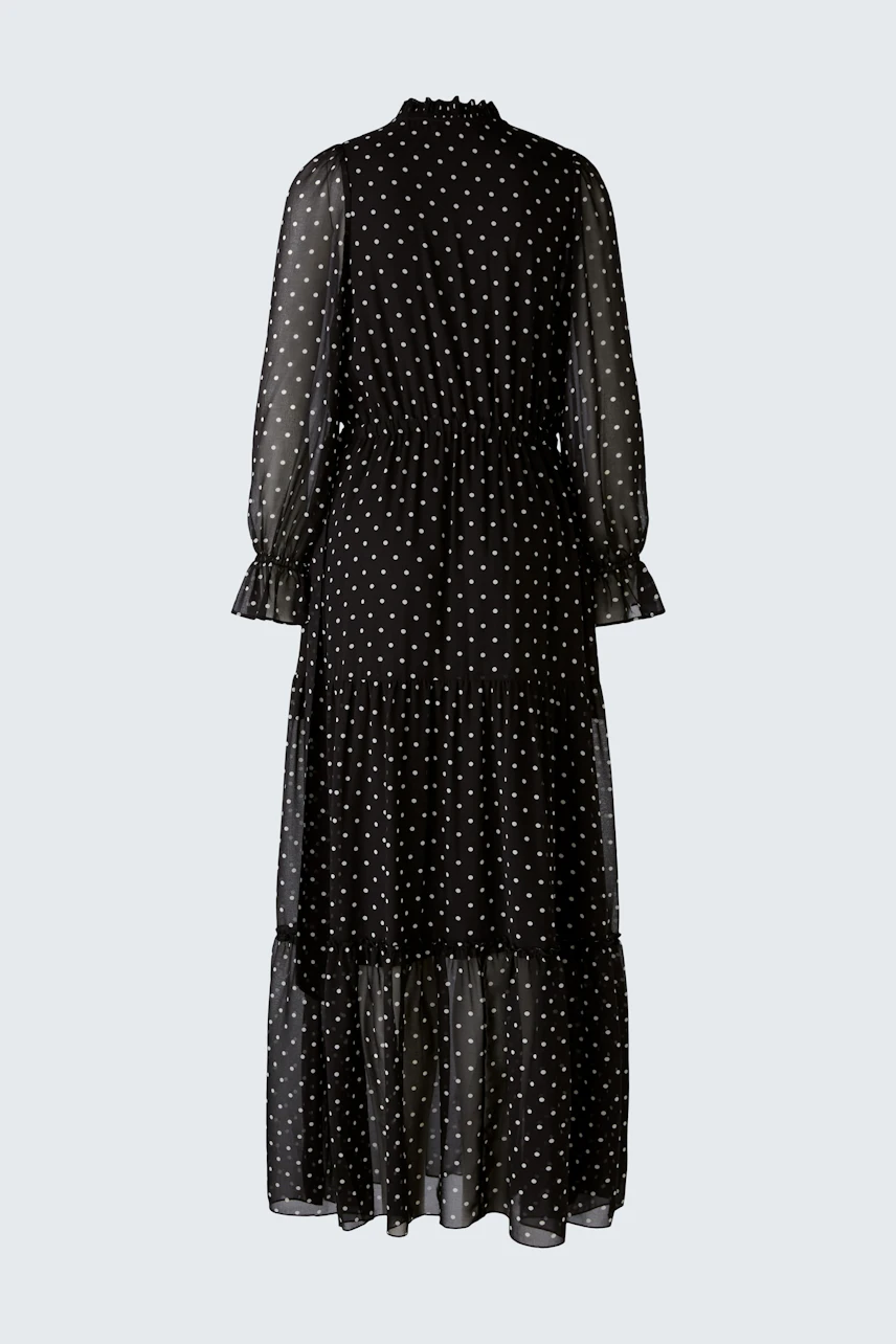 Elegantes Abendkleid: Schwarzes, gepunktetes Kleid mit langen Ärmeln und fließendem Schnitt.