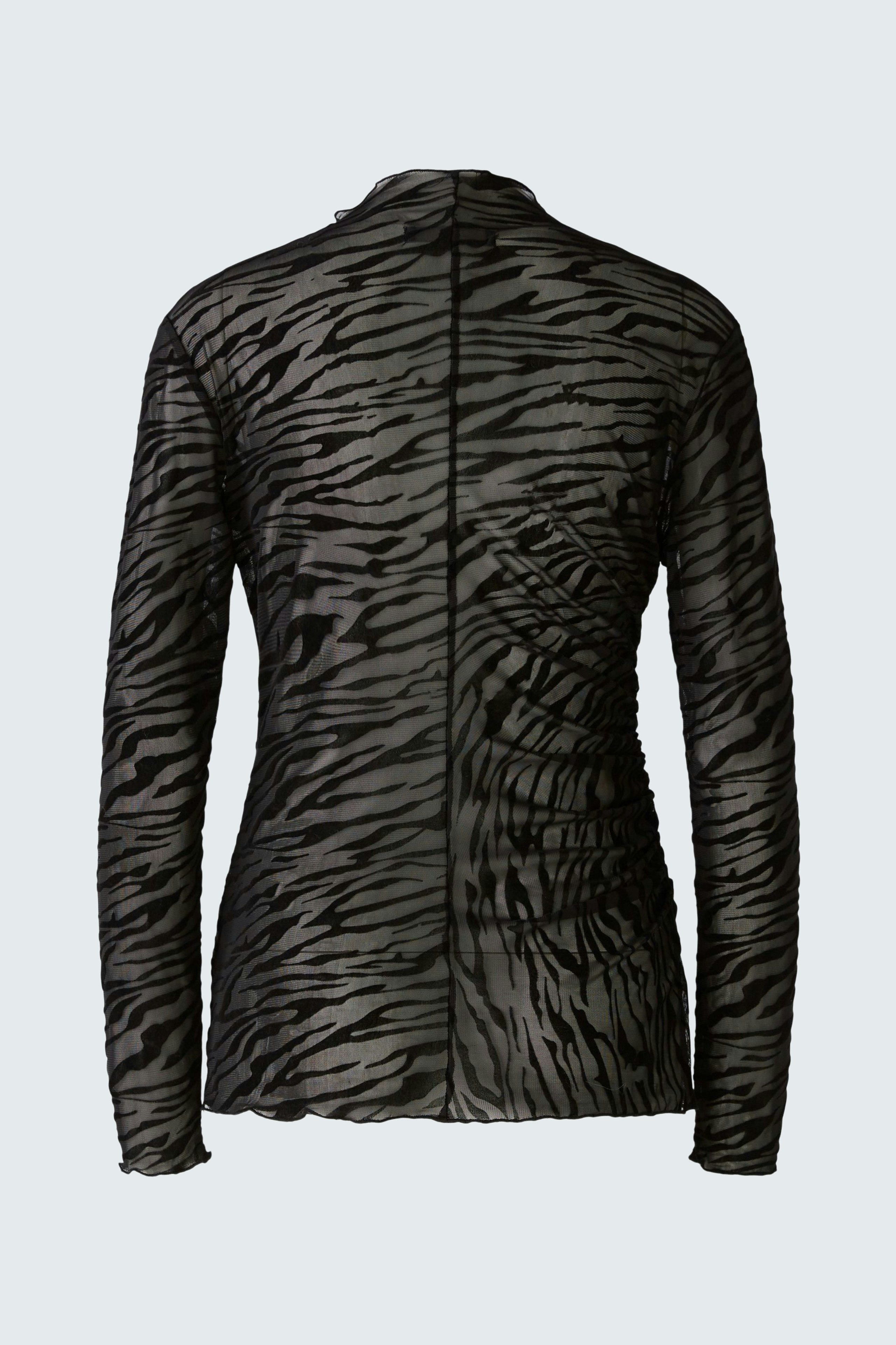 Stylish long-sleeve shirt: A woman in a black and gray patterned pullover, showcasing a modern design.