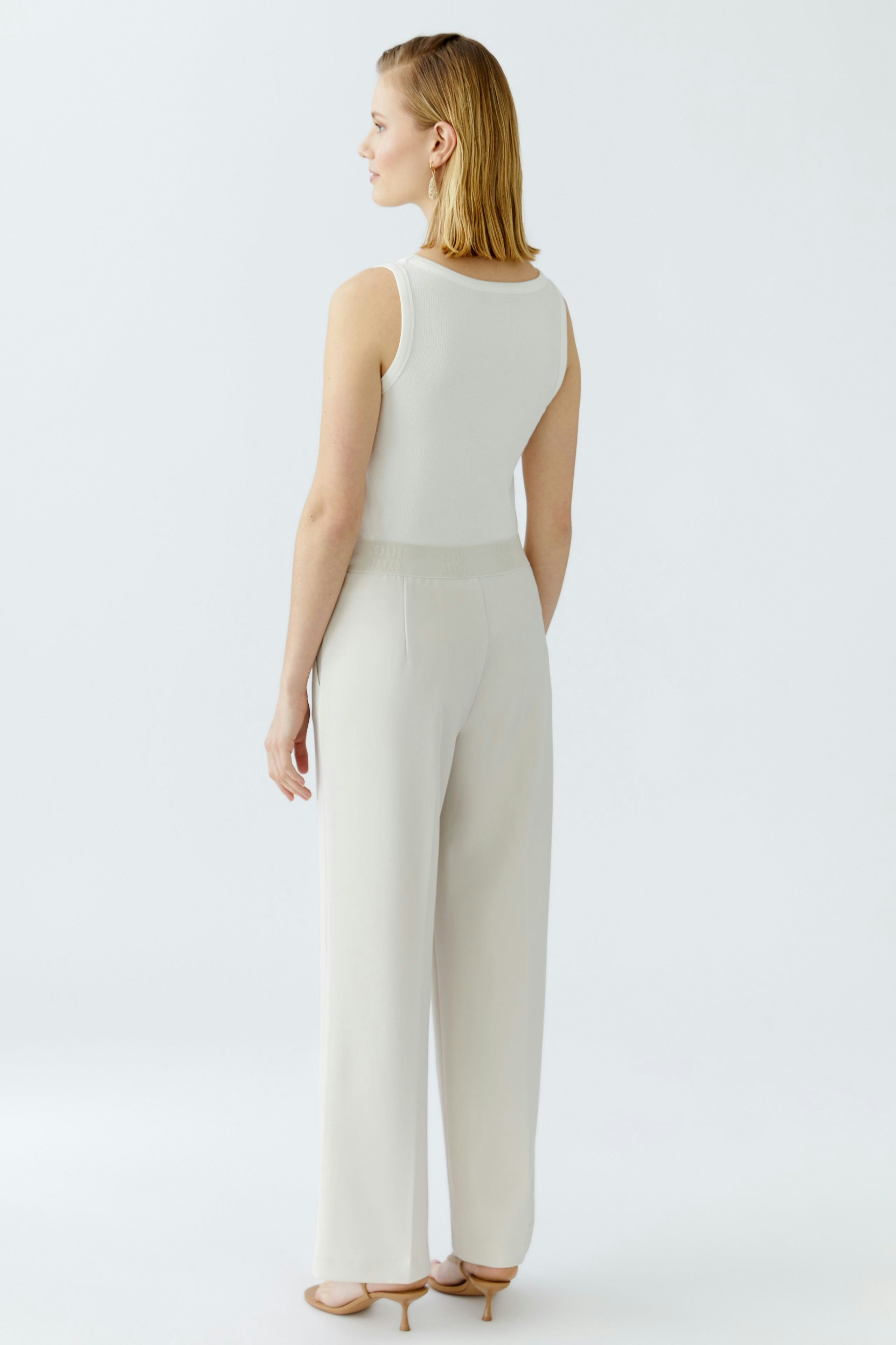 Elegante Damen-Hose: Frau in bequemer, heller Hose mit weitem Schnitt und elastischem Bund von hinten.