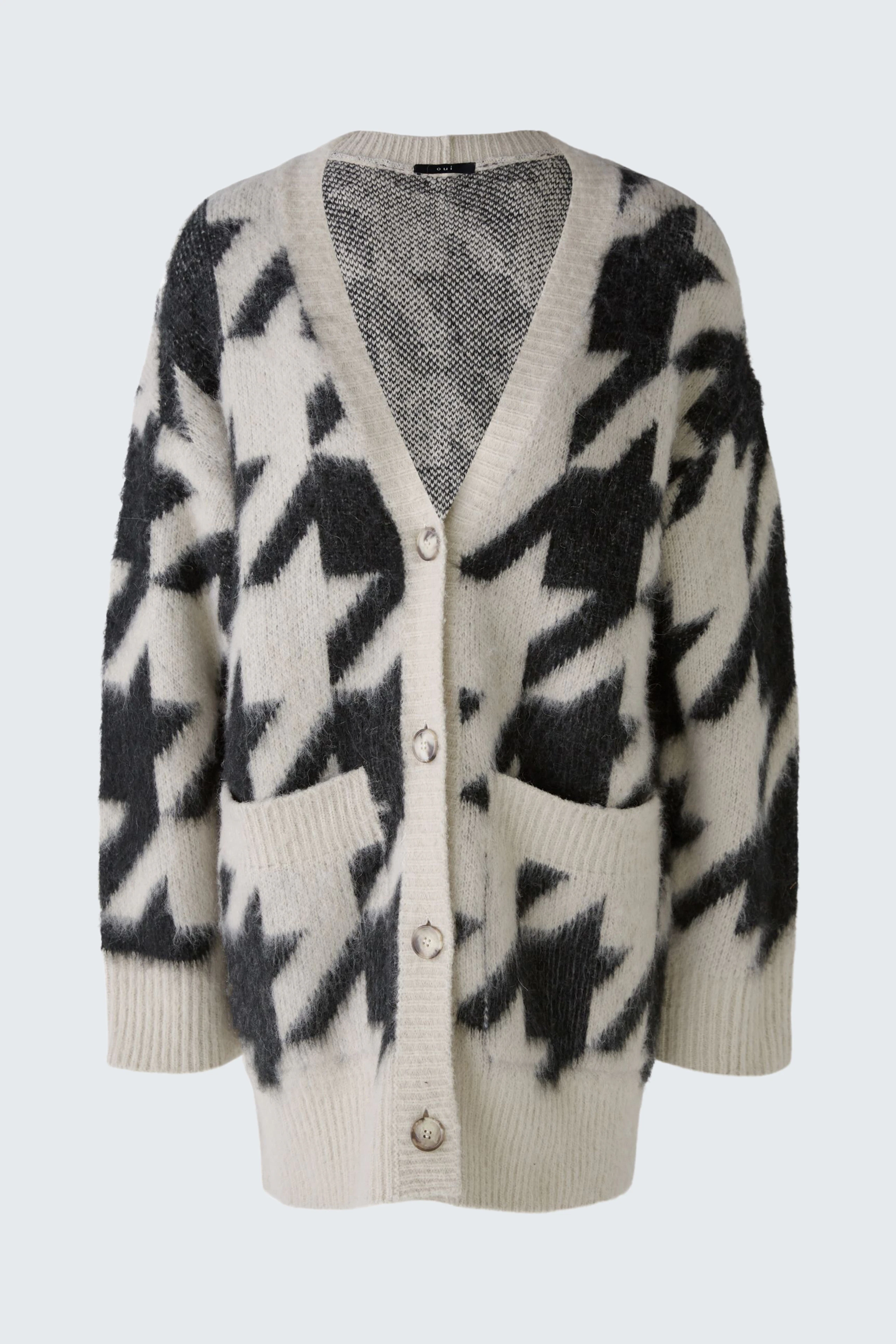Stylish women's cardigan in cream and black with a cozy design and button closure.