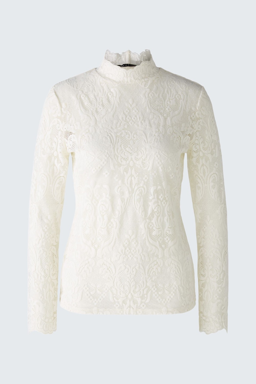 Elegant long-sleeve shirt: A woman in a white textured pullover with a high collar.