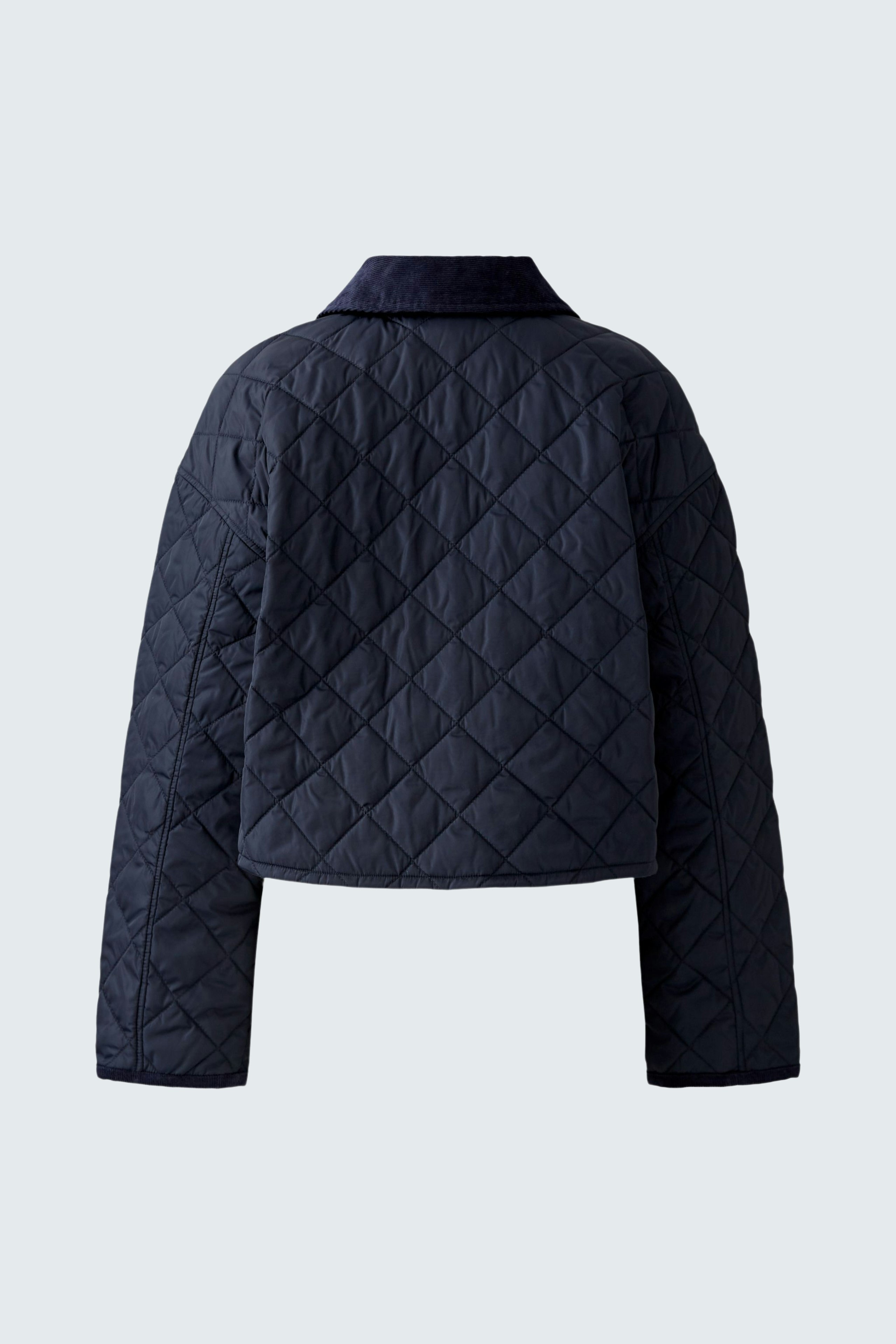 Stylish outdoor jacket: A woman in a navy quilted jacket with a modern cropped design.