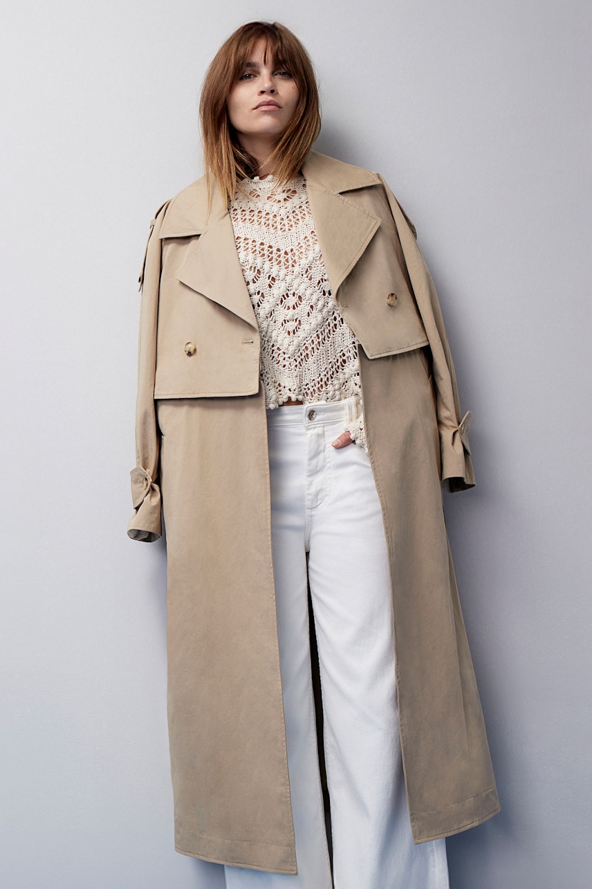 Stylish trench coat: A woman in a beige trench coat over a white top and wide-leg pants.