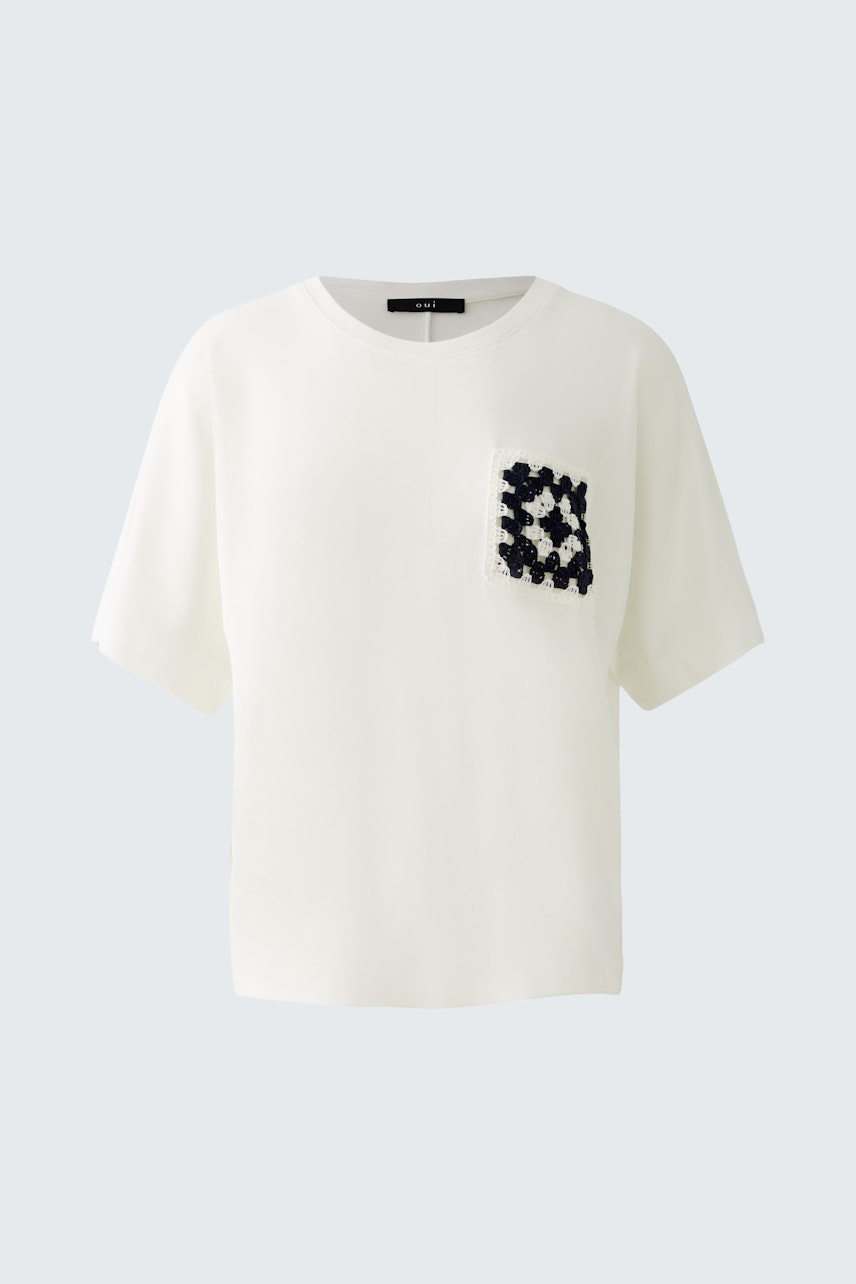 Stylish women's T-shirt: White top with a unique pocket design, perfect for casual wear.