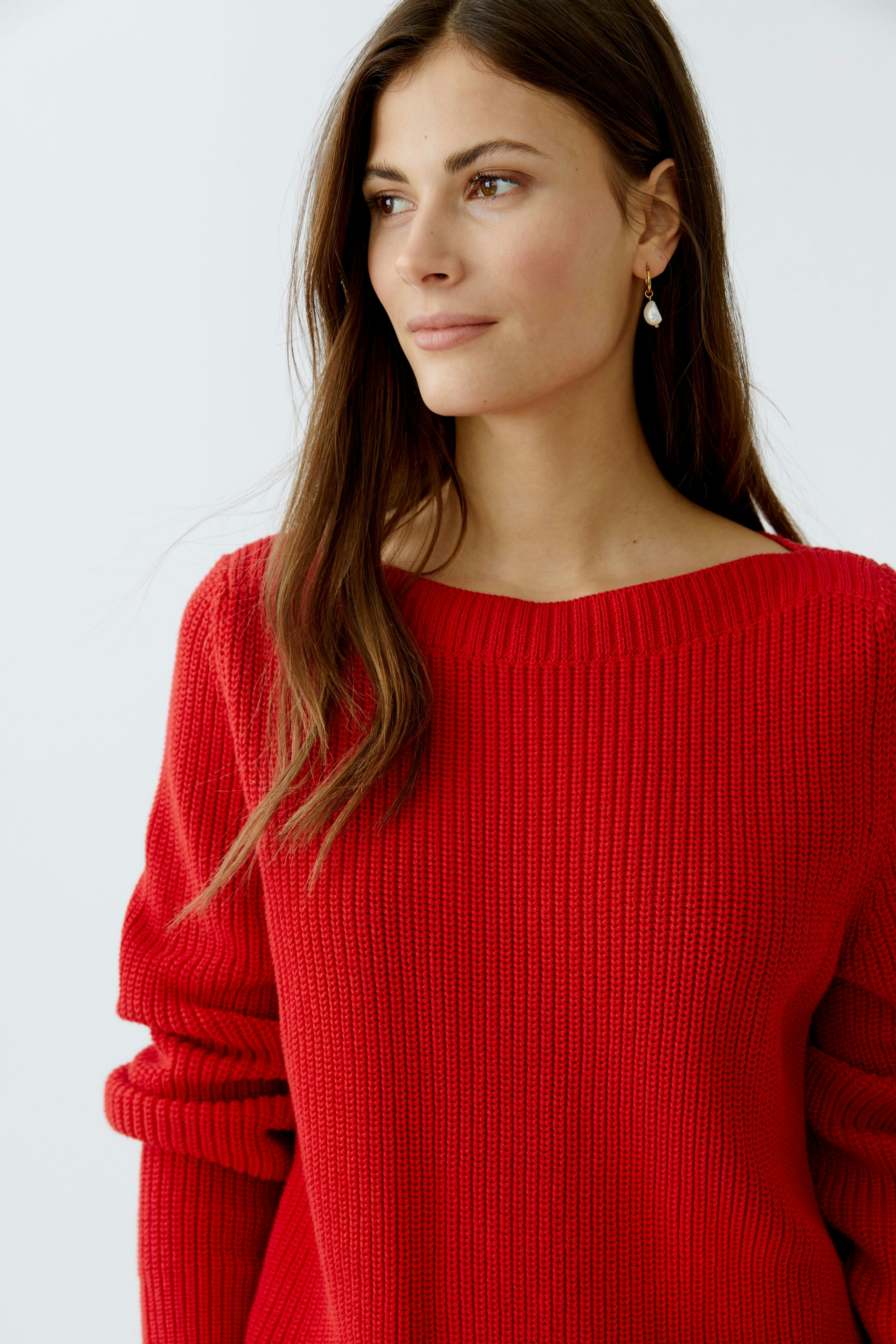 Modern women's pullover: A woman in a vibrant red knit pullover with a relaxed fit.