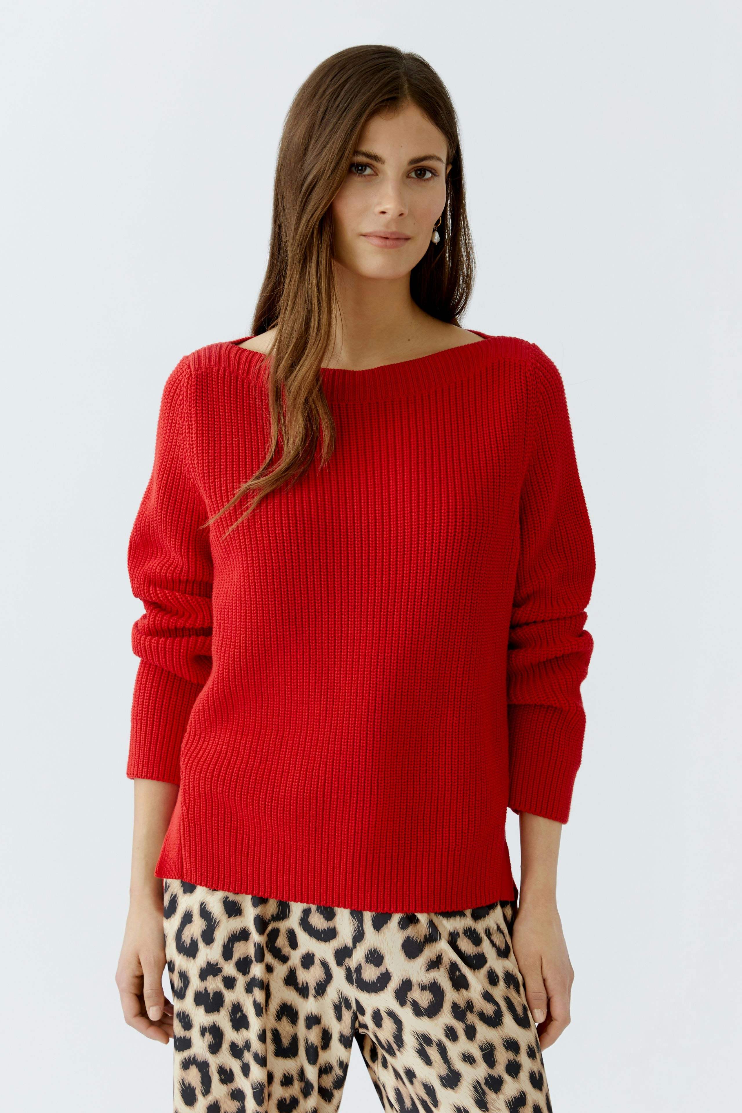 Stylish women's pullover: A woman in a red ribbed pullover paired with leopard print pants.