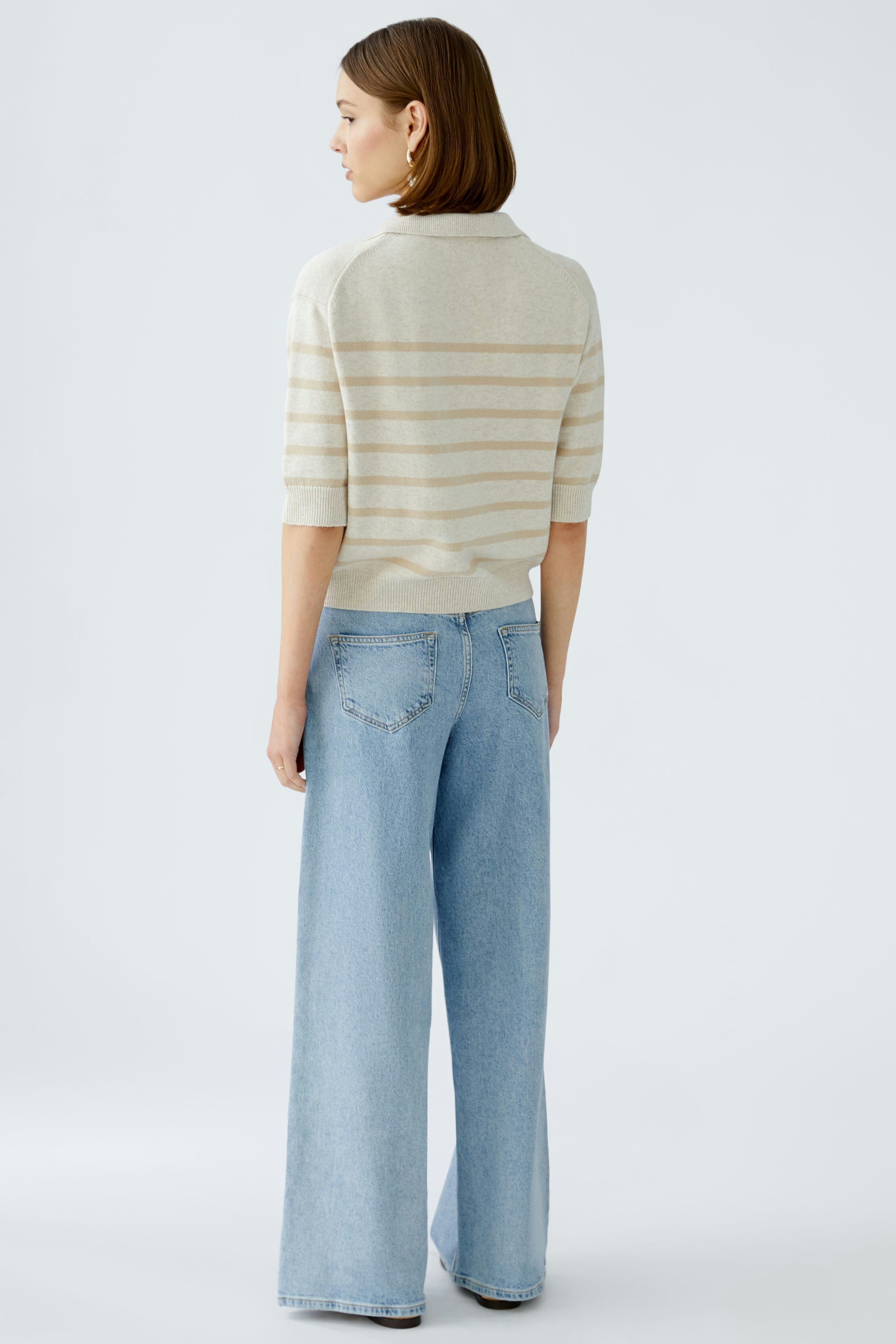 Stylish women's pullover: A woman in a striped pullover with a relaxed fit, paired with wide-leg jeans.