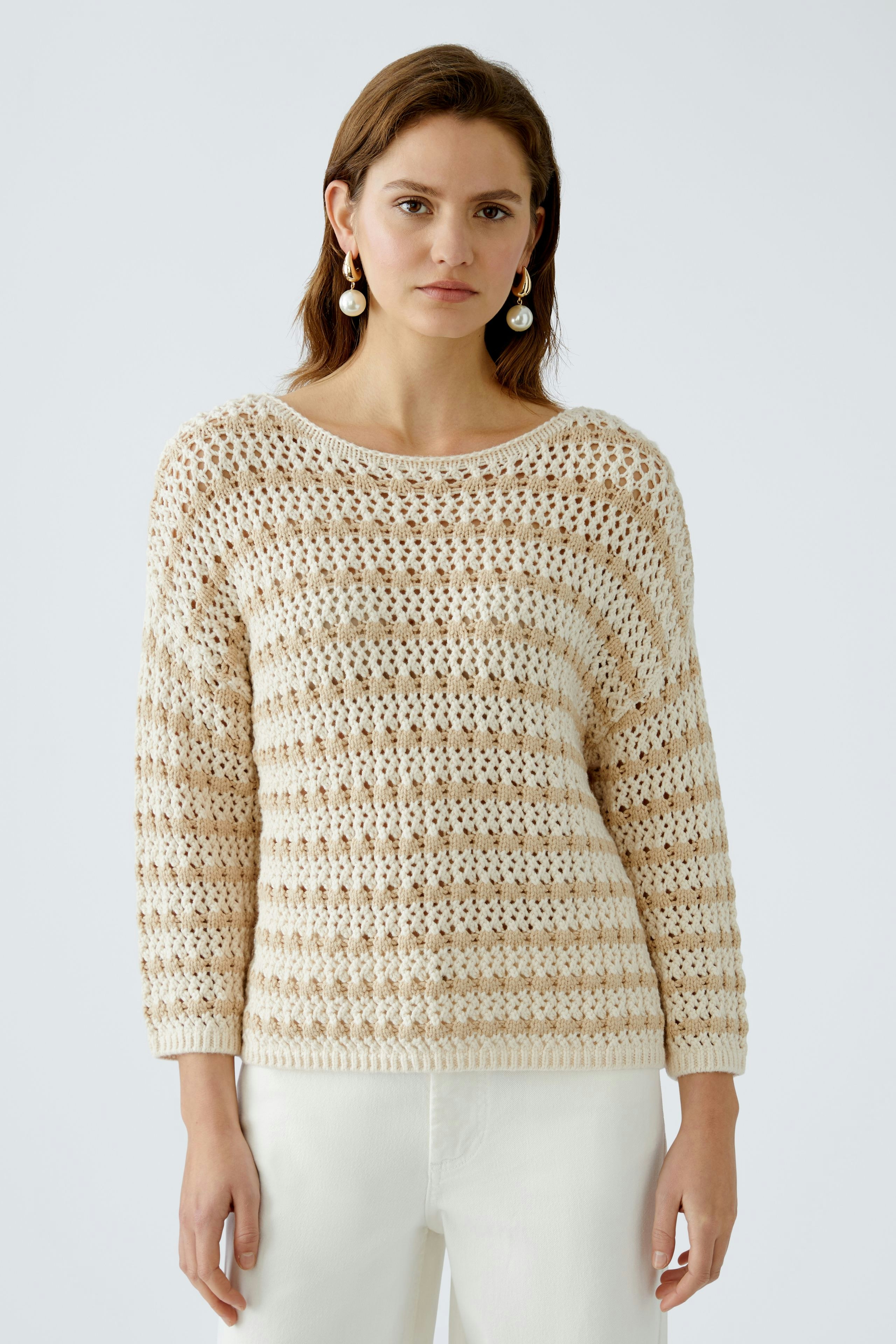 Stylish women's pullover: A woman in a light striped pullover with a relaxed fit.