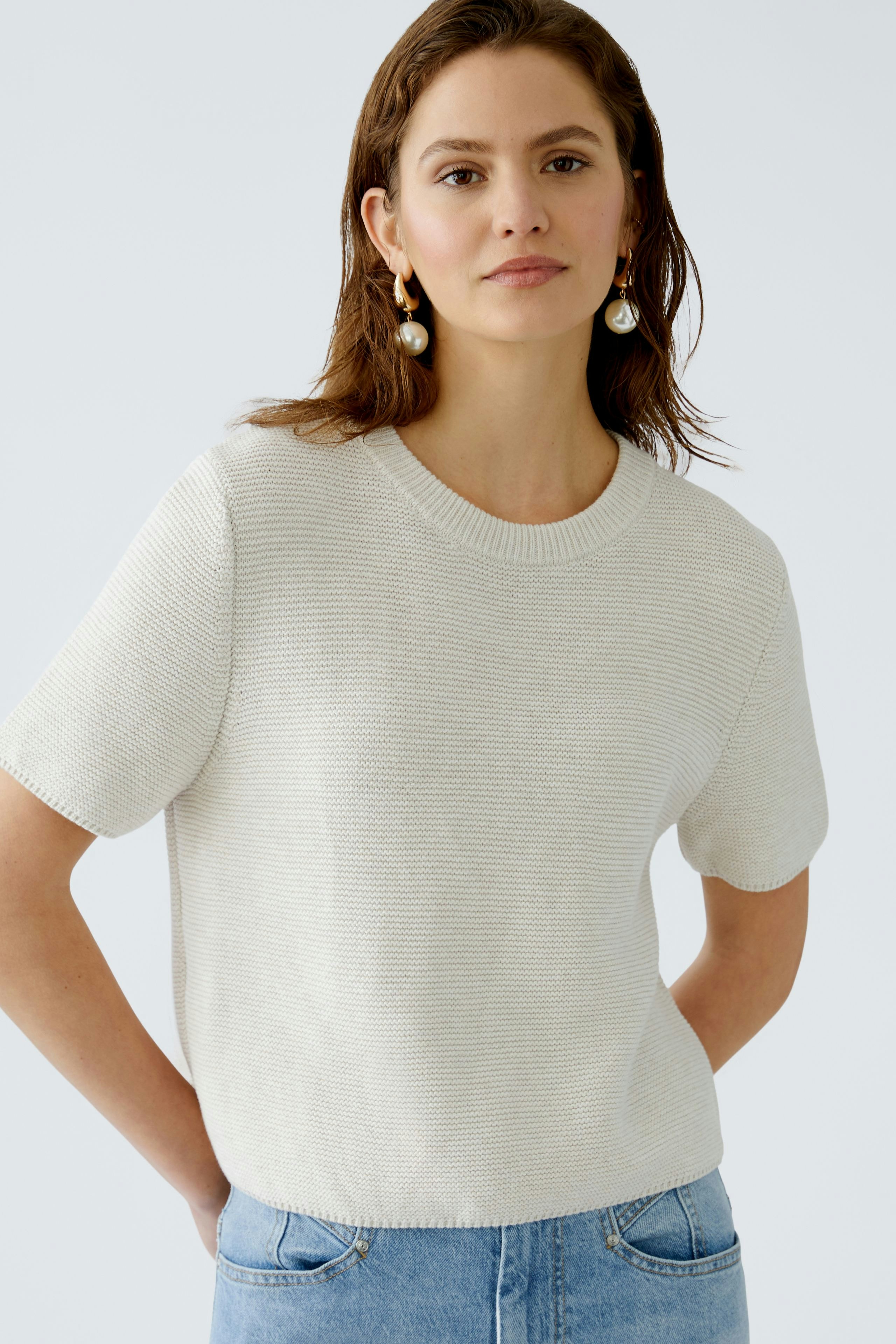 Stylish women's pullover: A woman in a light beige short-sleeve pullover, exuding casual elegance.