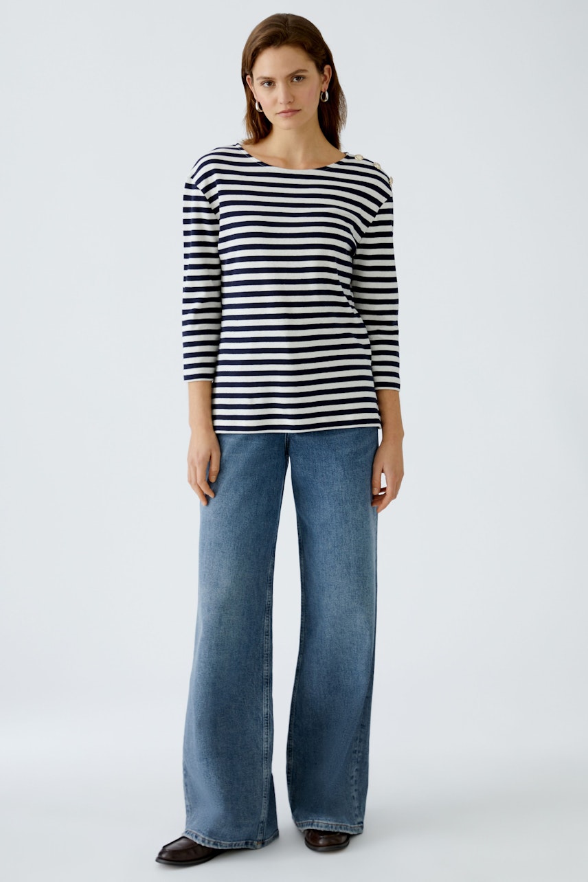 Stylish women's long-sleeve shirt: A woman in a striped pullover pairs it with wide-leg jeans.