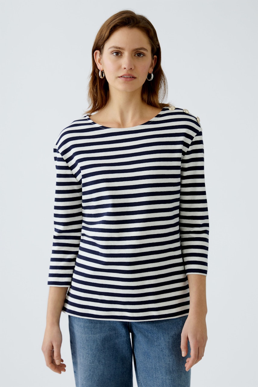 Stylish long-sleeve shirt: Woman in a navy and white striped pullover, exuding casual elegance.