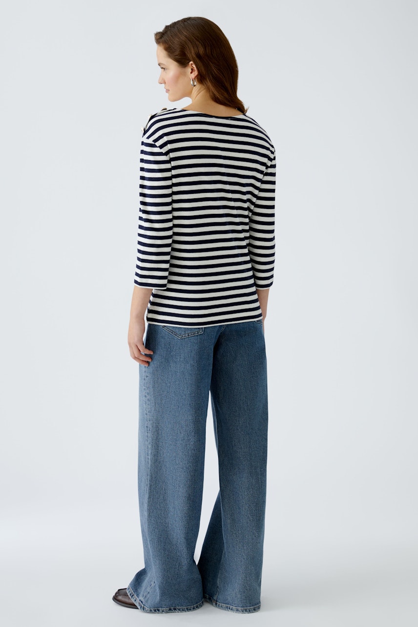 Stylish women's long-sleeve shirt: A woman in a striped pullover, paired with wide-leg jeans.