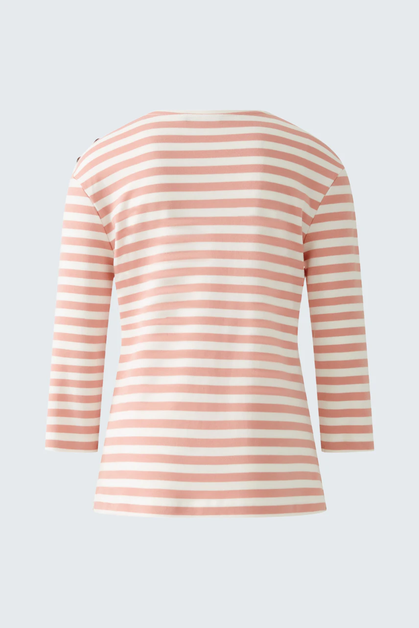 Stylish long-sleeve shirt: A woman in a pink and white striped pullover, showcasing a casual look.