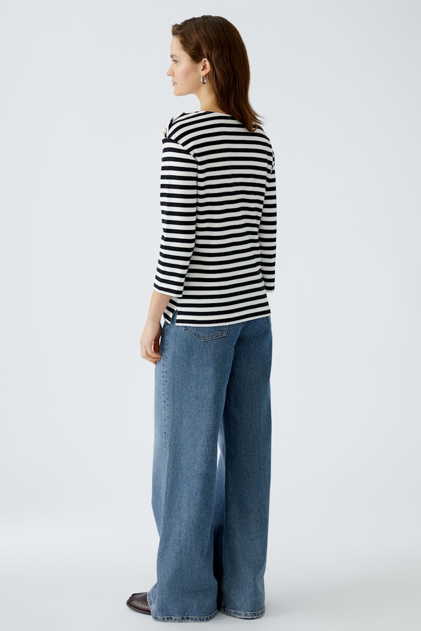 Stylish women's long-sleeve shirt: A woman in a striped pullover with a relaxed fit.