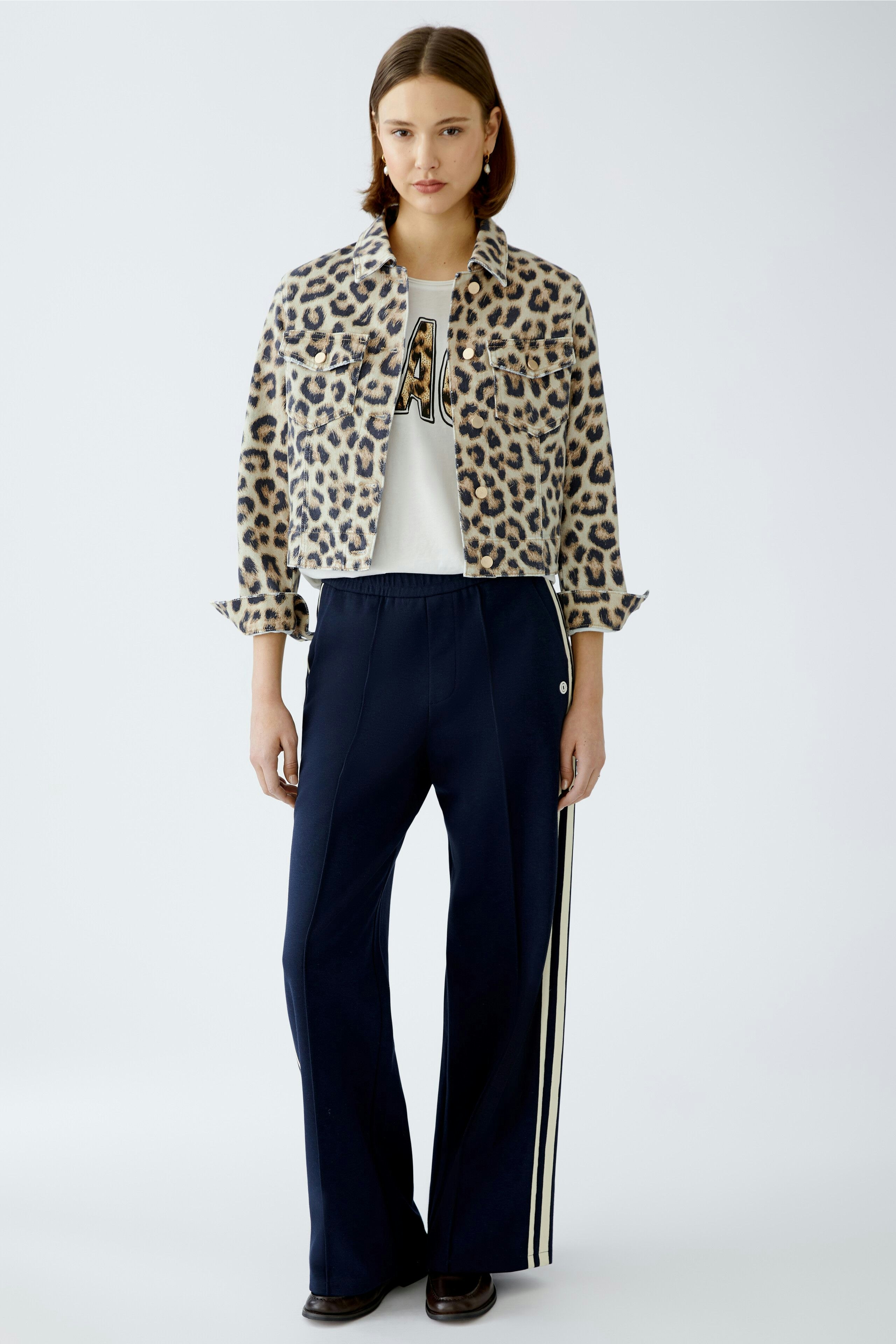 Stylish women's denim jacket with a leopard print, paired with a casual outfit.
