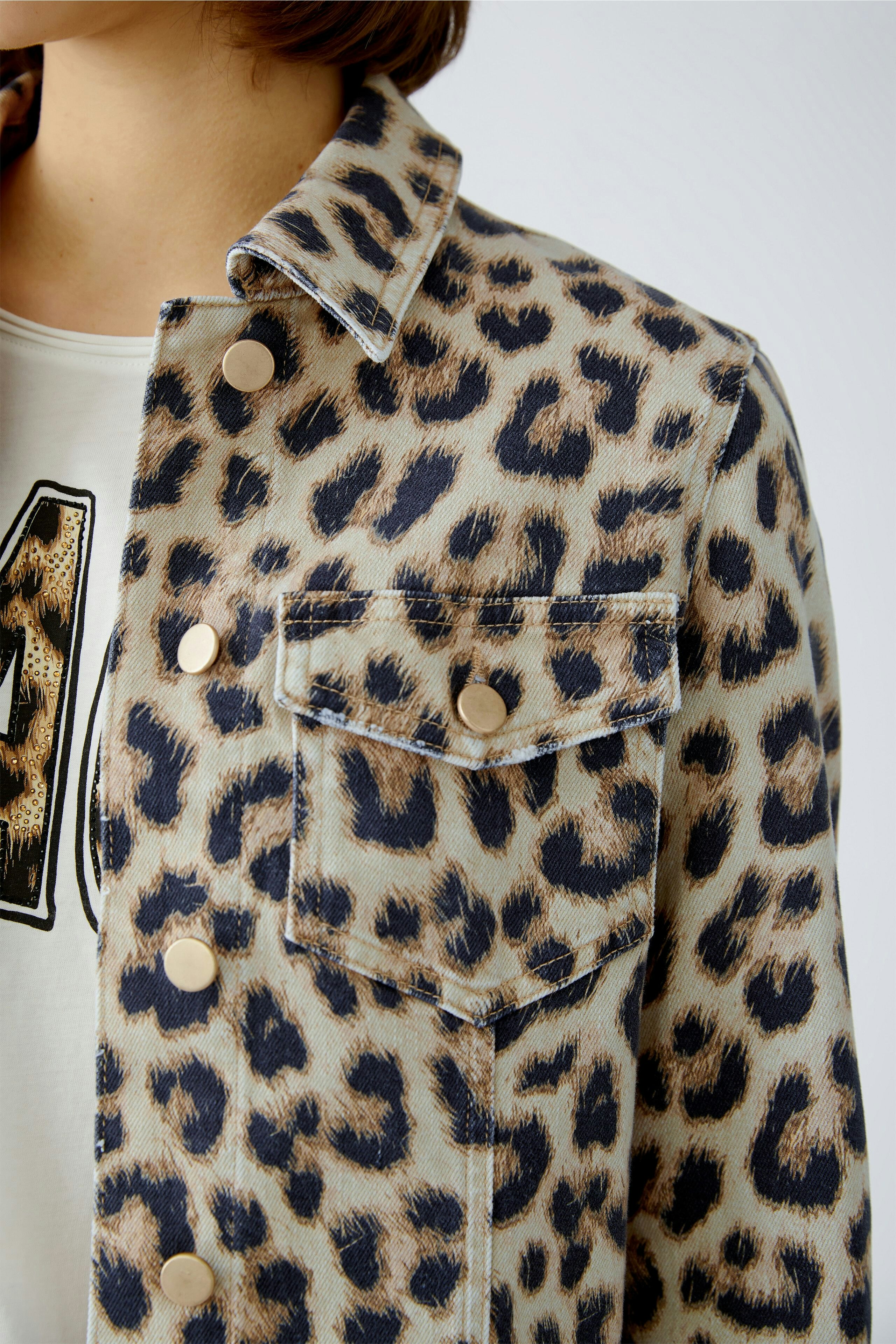 Stylish women's denim jacket with a leopard print, featuring button closure and chest pockets.