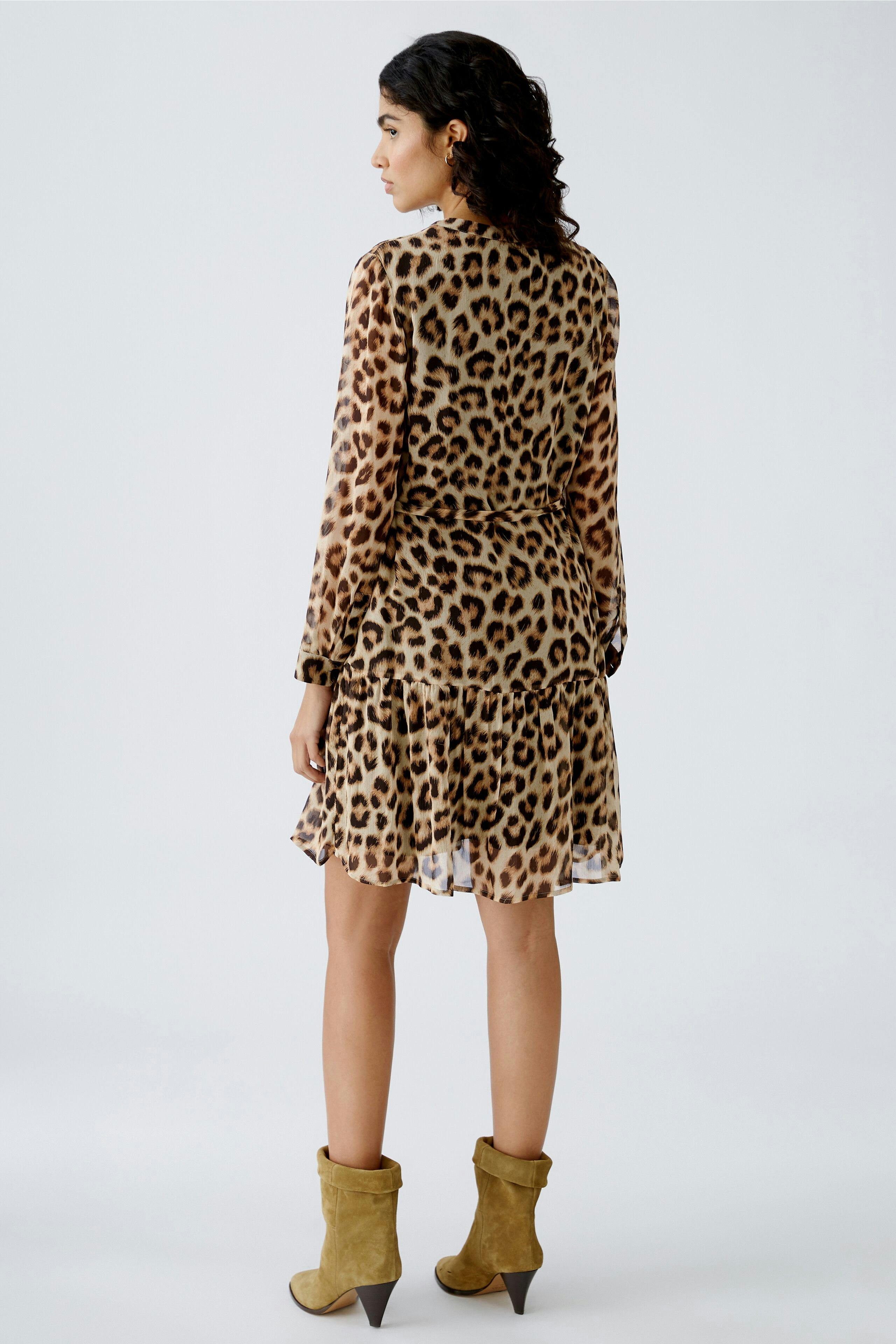 Chic women's dress: A woman in a leopard print dress with a ruffled hem, showcasing a stylish back view.