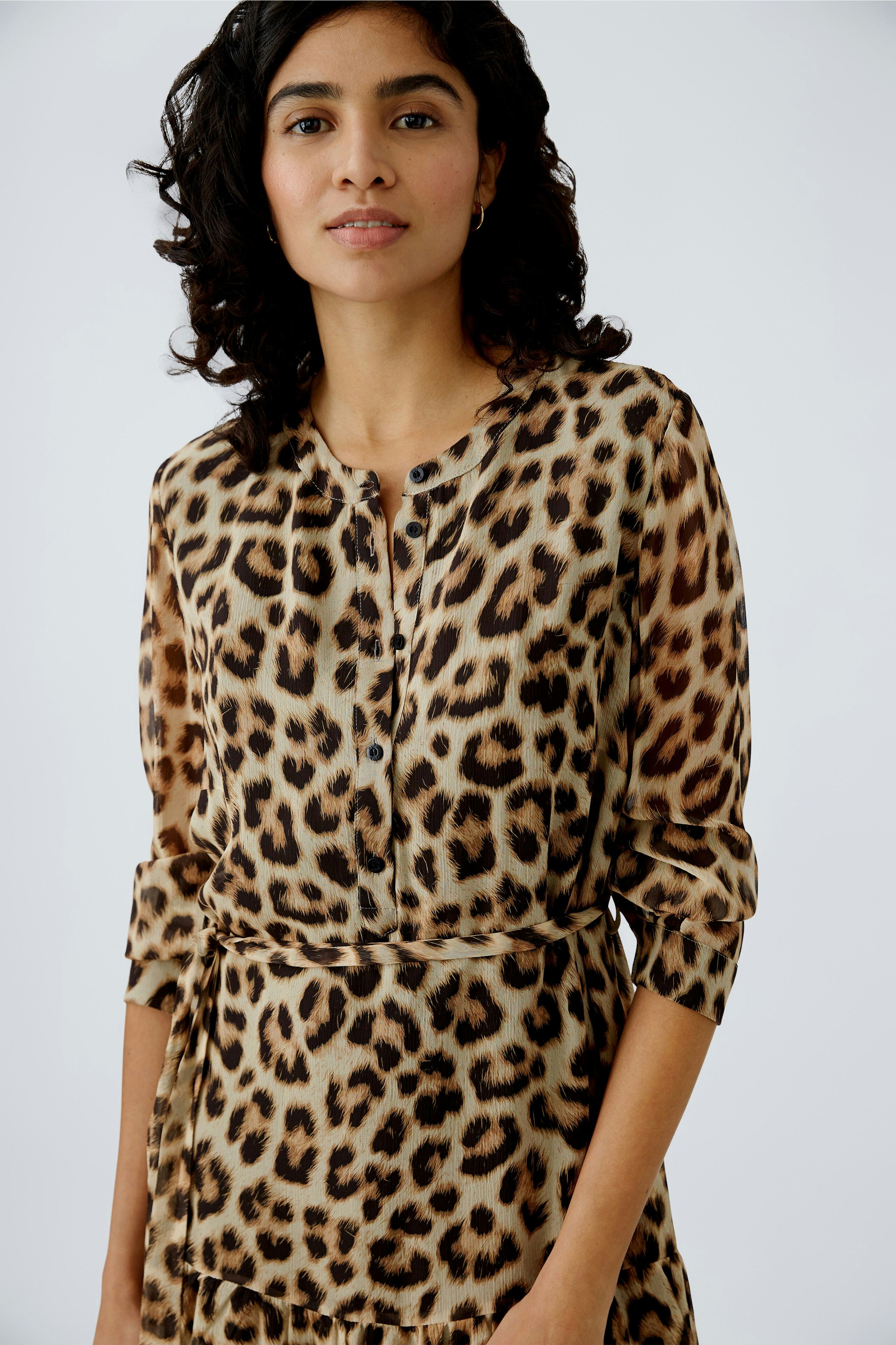 Stylish women's dress: A woman in a leopard print dress with a buttoned neckline and flowing silhouette.