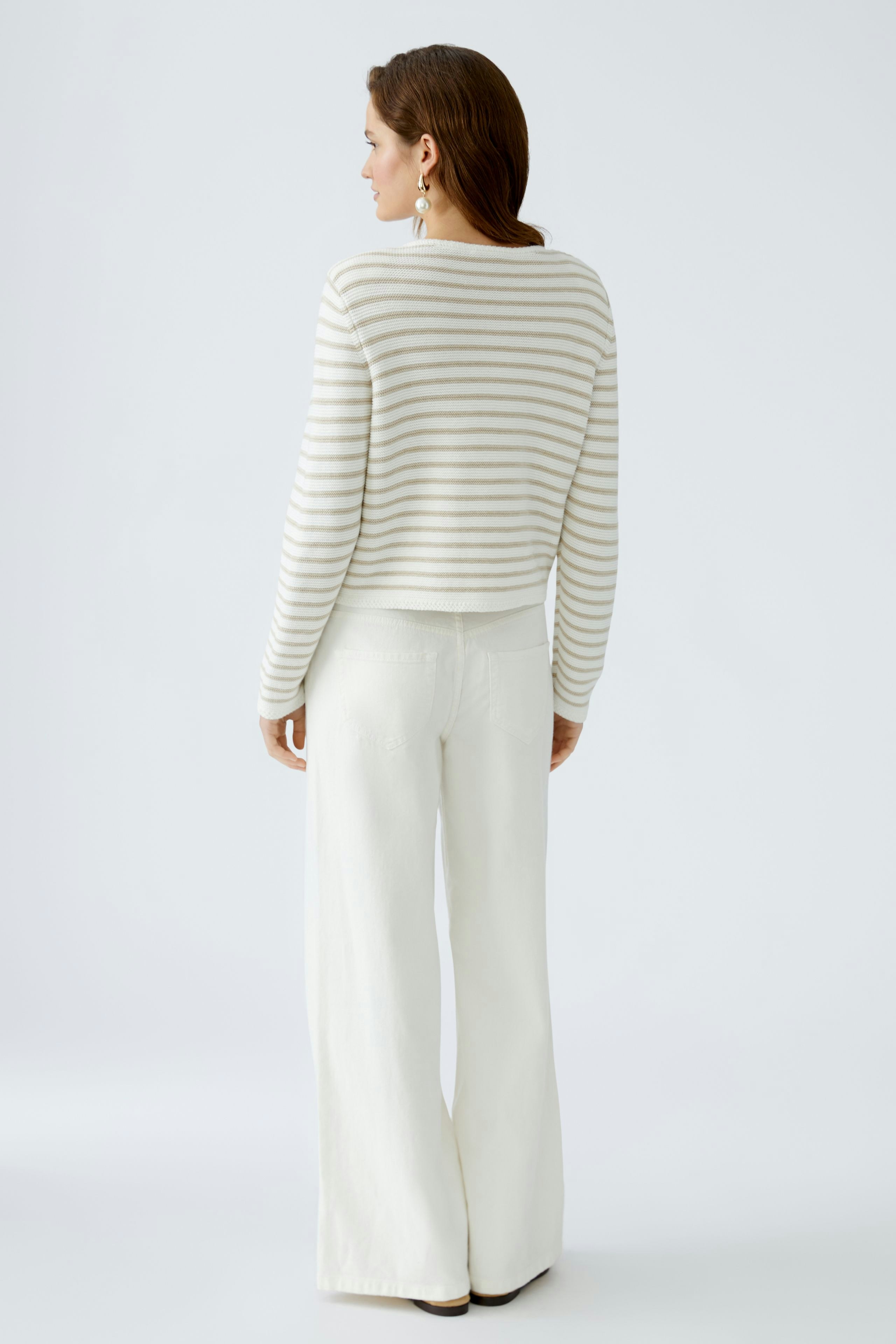Stylish women's cardigan: A woman in a striped pullover with wide-leg pants, showcasing a relaxed look.