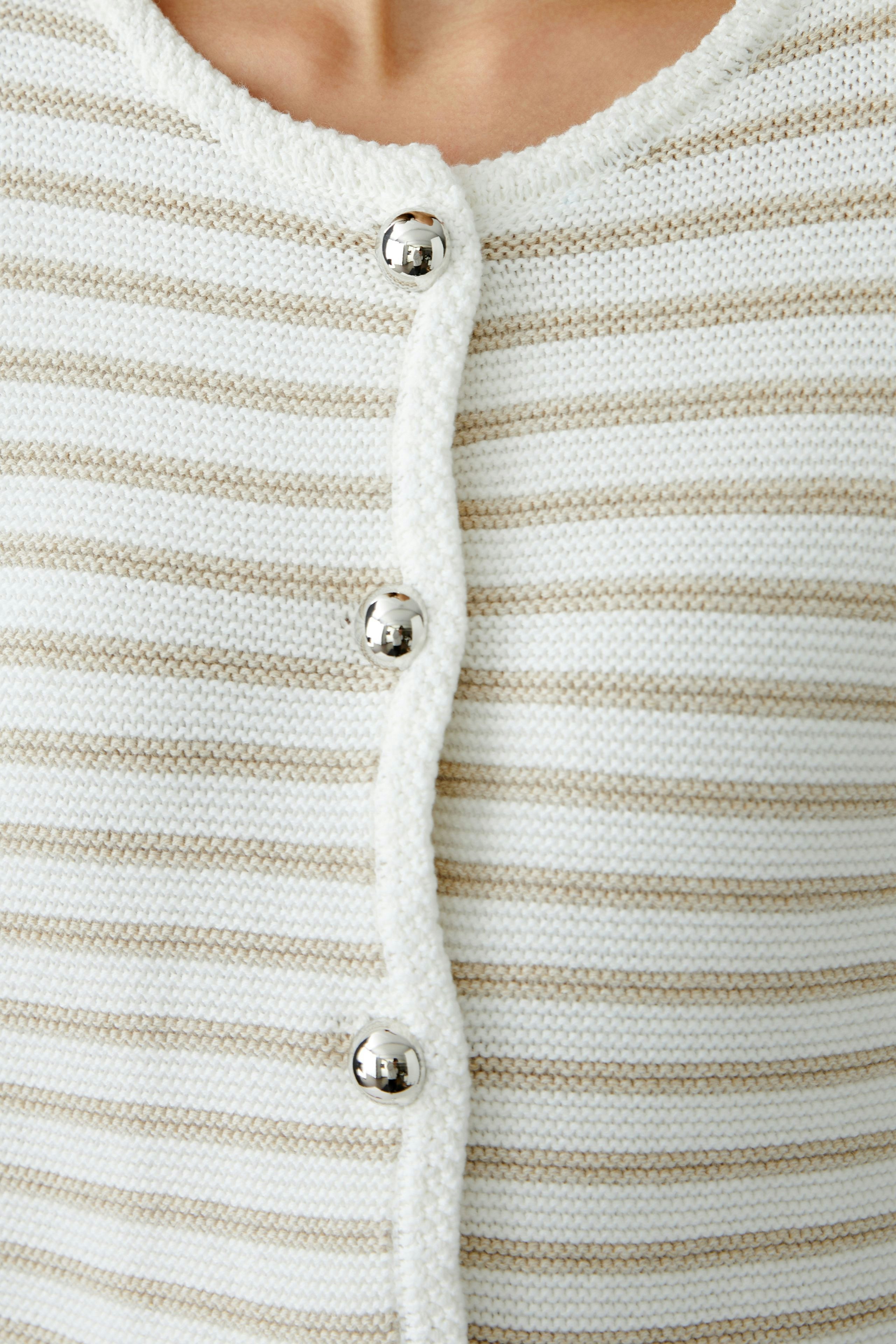 Stylish women's cardigan: Close-up of a woman in a striped cardigan with buttons, perfect for layering.
