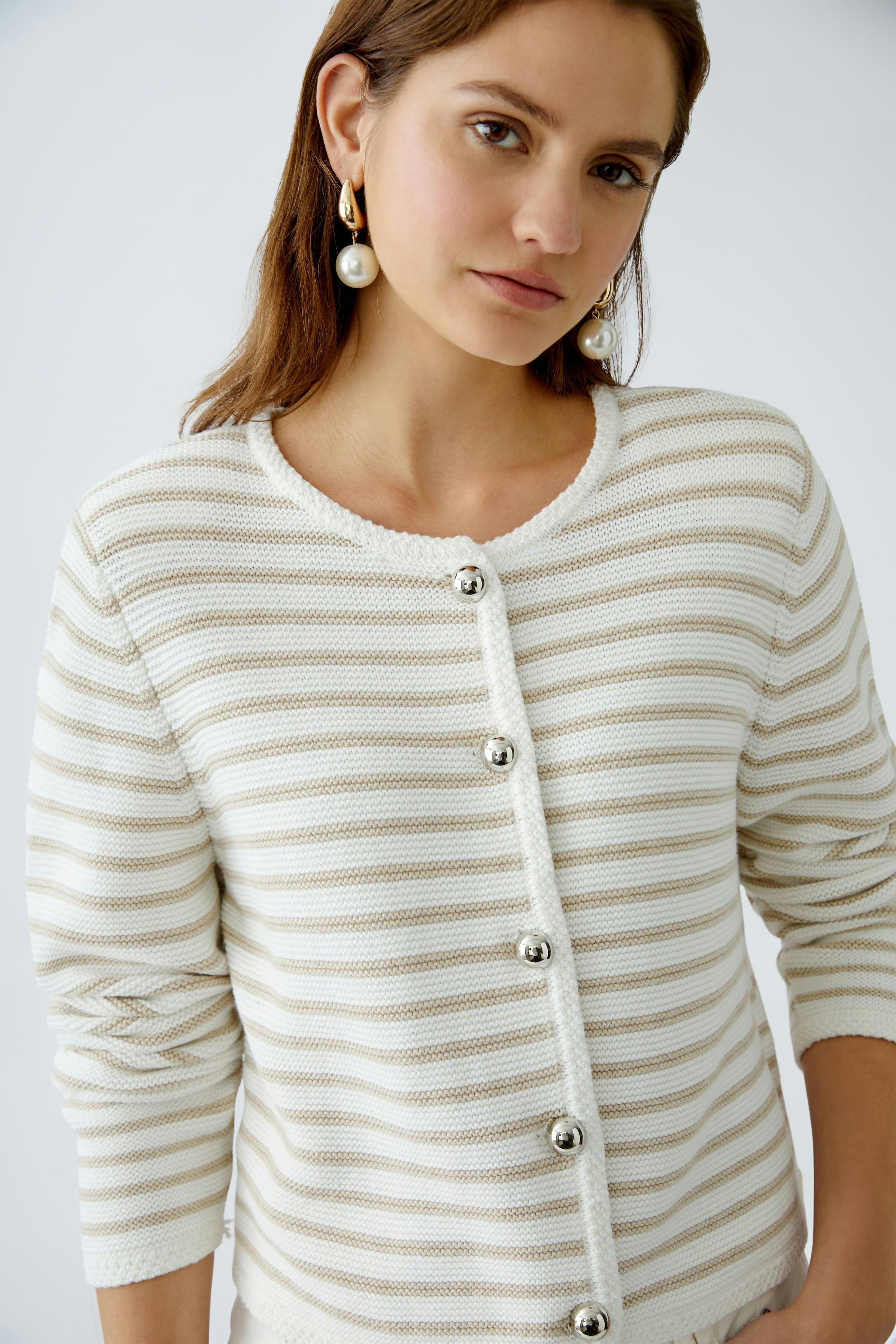 Stylish women's cardigan: A woman in a striped cardigan with button details, exuding elegance.