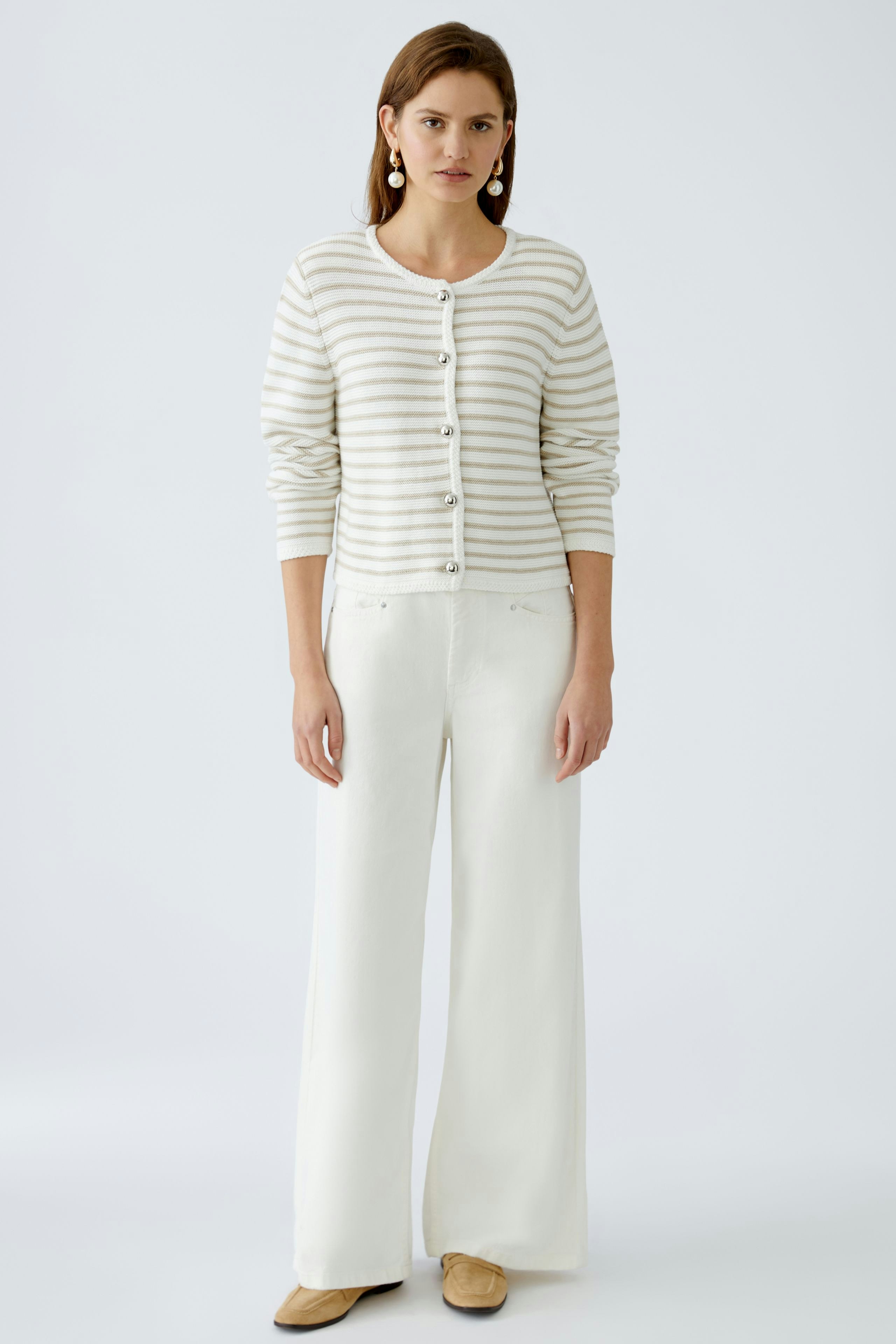 Stylish women's cardigan: A woman in a striped cardigan with buttons, paired with wide-leg trousers.