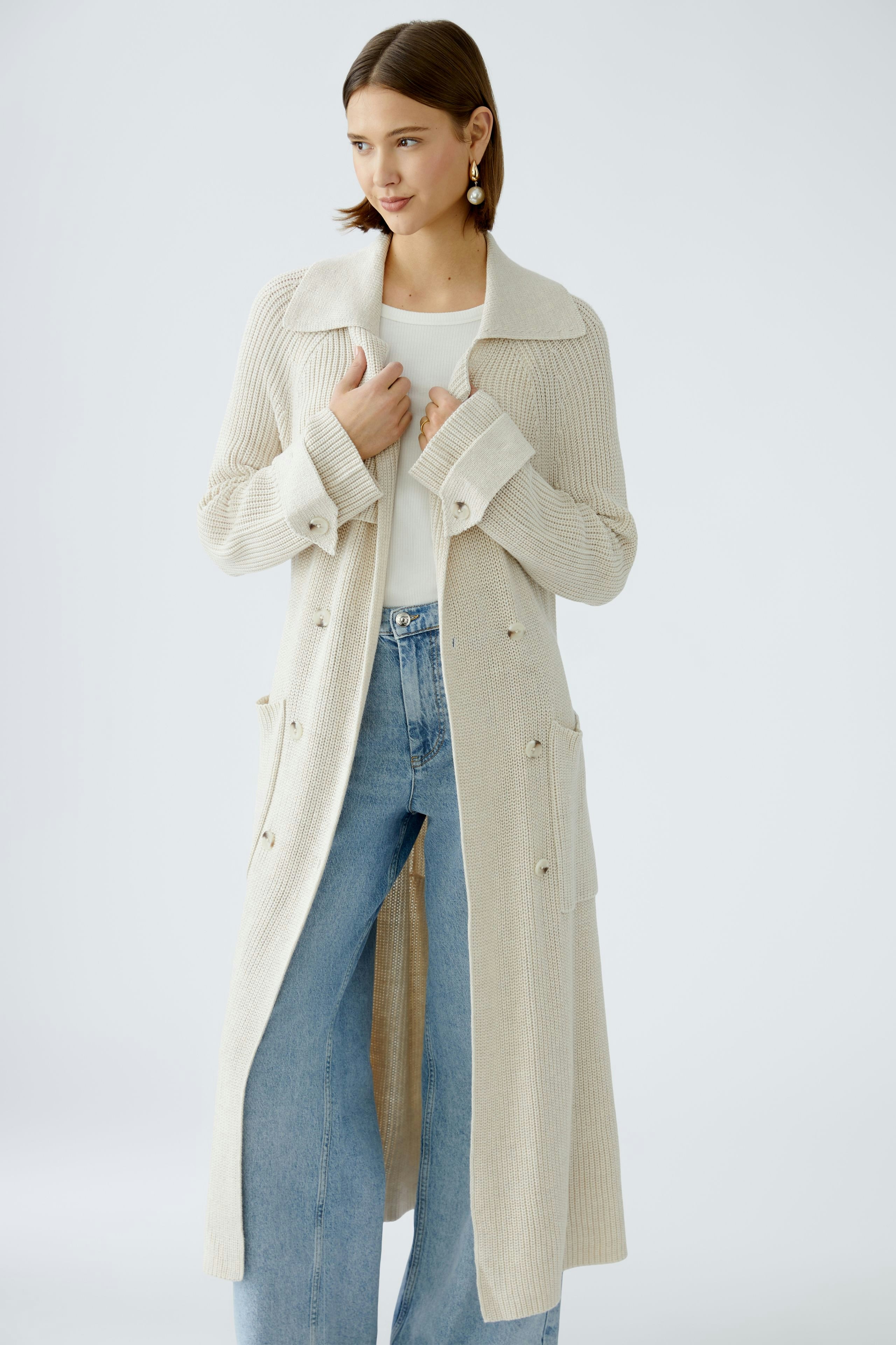 Stylish women's cardigan: A woman in a beige knitted coat with a relaxed fit and elegant details.