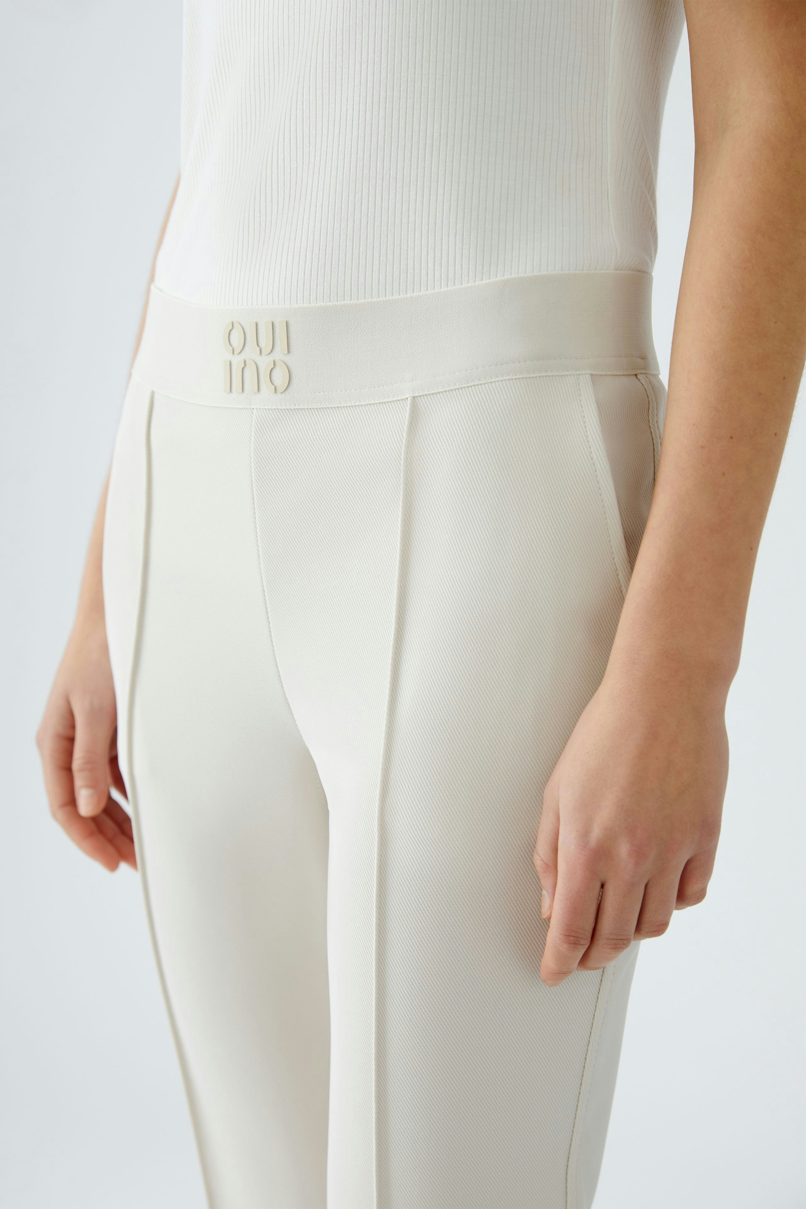 Elegant women's trousers in soft cream fabric, featuring a comfortable waistband and tailored fit.