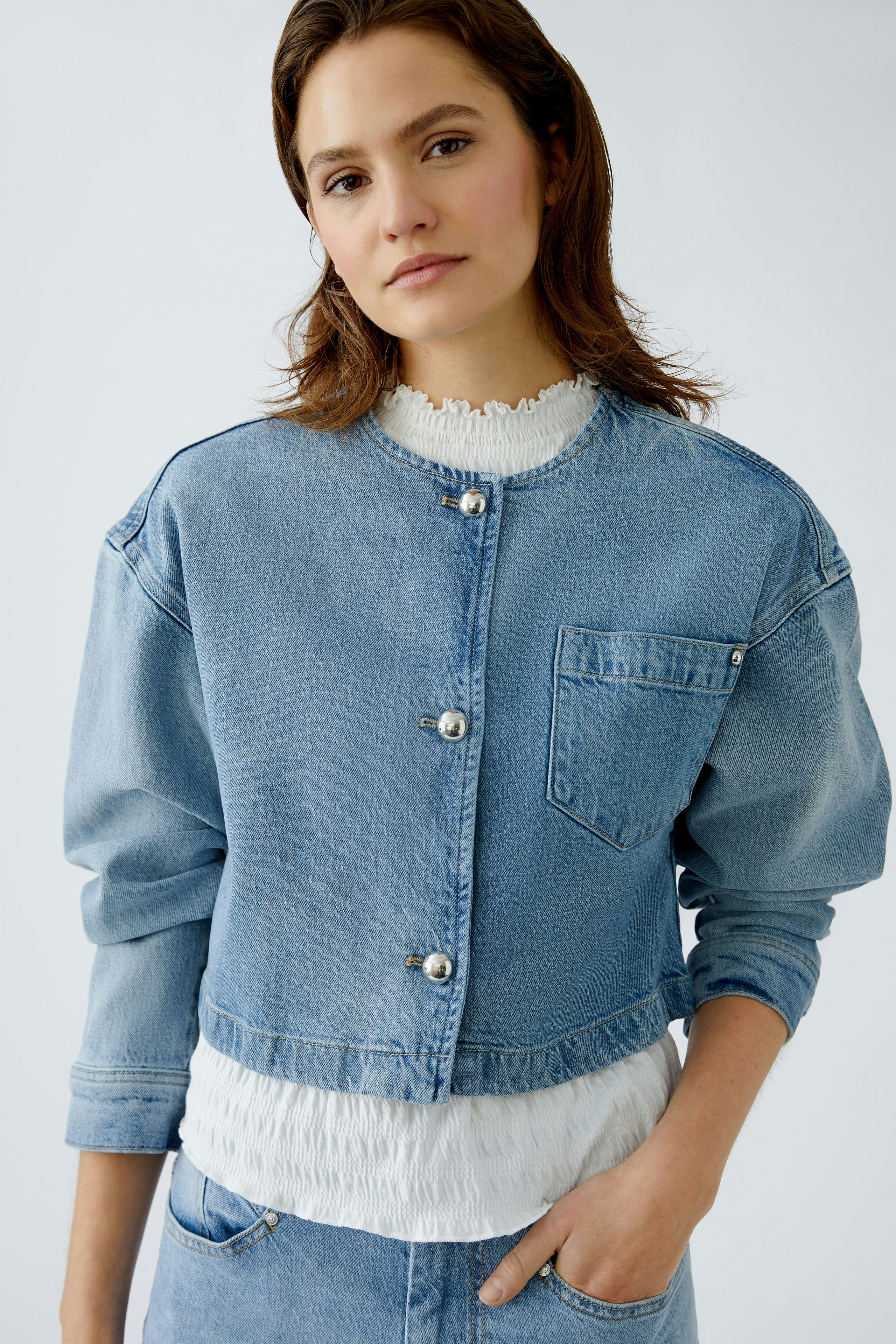 Moderne Jeansjacke: Junge Frau in blauer Jeansjacke mit Knöpfen und lässigem Look.