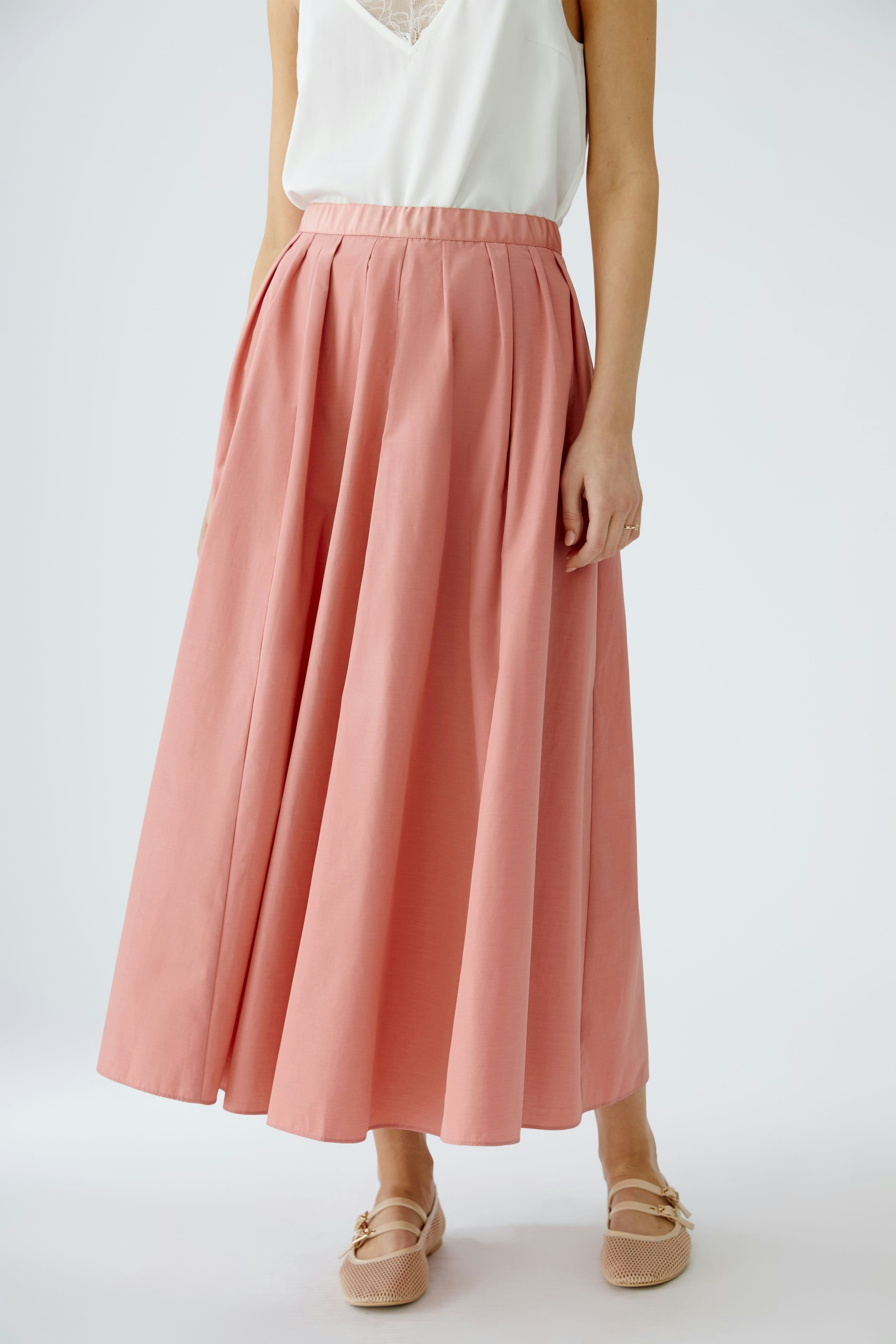 Elegant maxi skirt: Woman in a flowing pink maxi skirt with a comfortable waistband and stylish design.