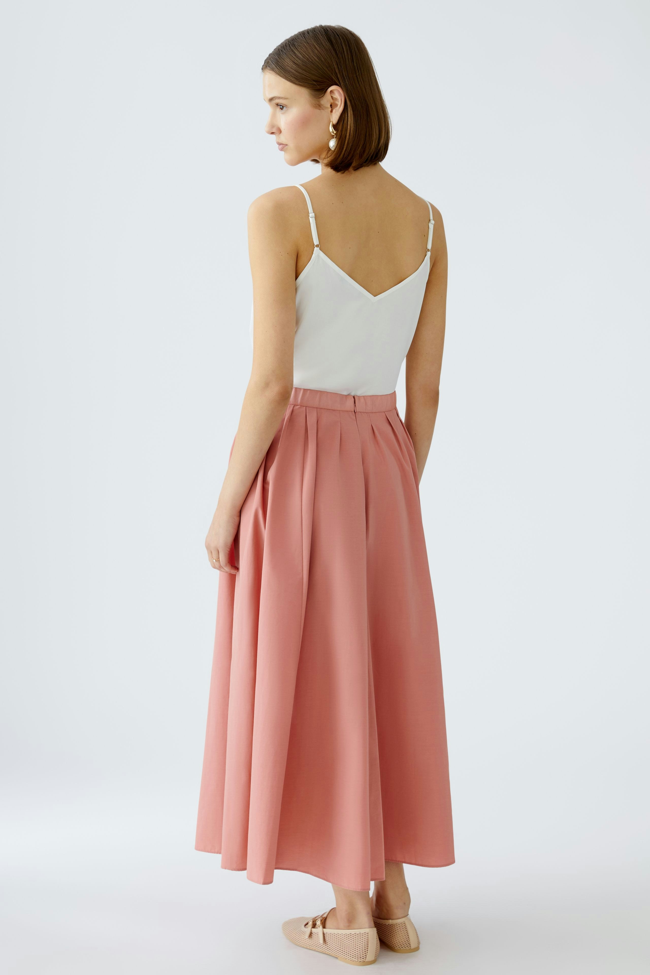 Elegant maxi skirt: Woman in a flowing pink maxi skirt, showcasing a stylish and comfortable design.