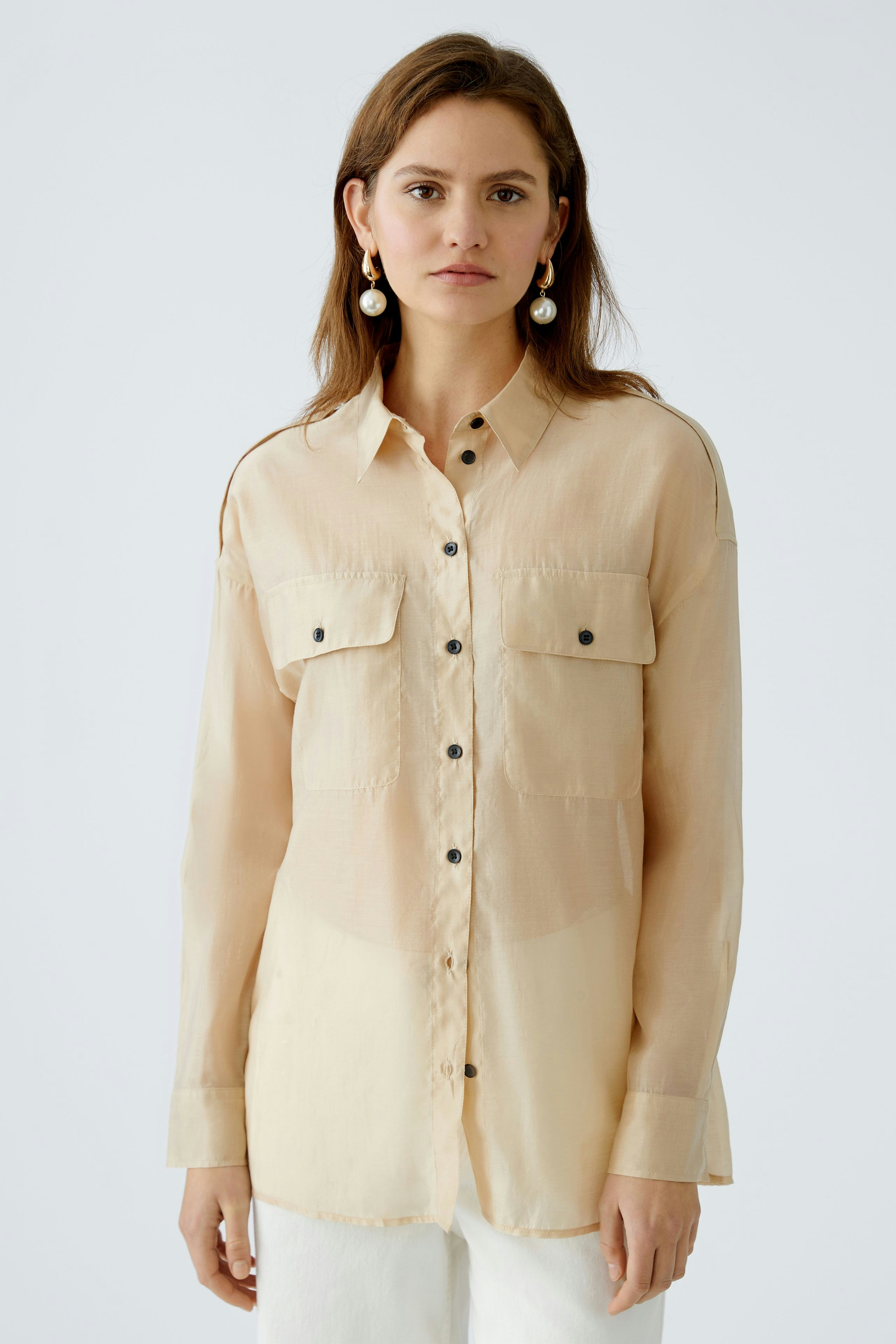 Lightweight women's blouse with button-down front and chest pockets, perfect for casual wear.