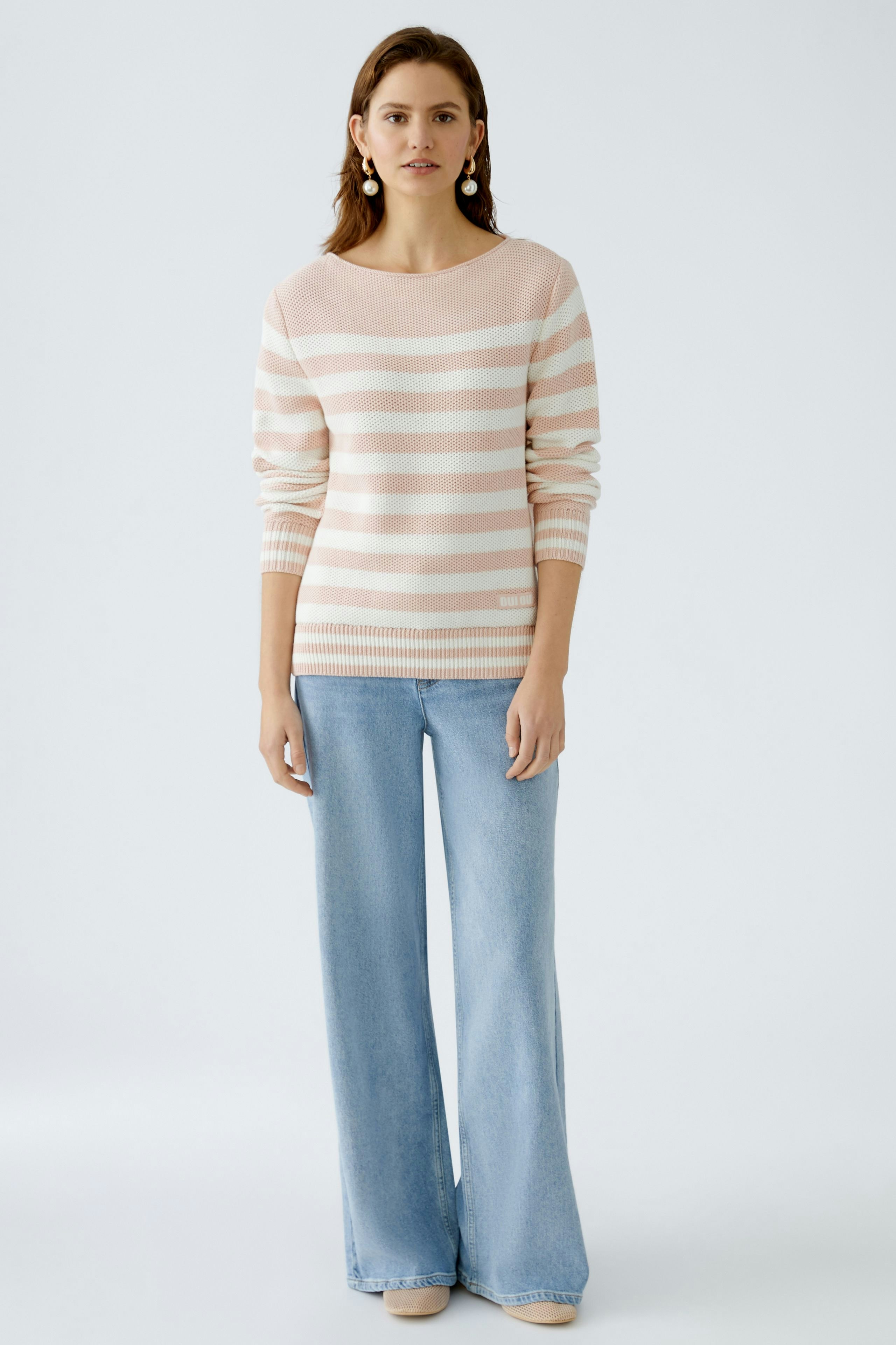 Damen-Pullover: Frau in gestreiftem Pullover mit lässigem Schnitt und weichem Material.