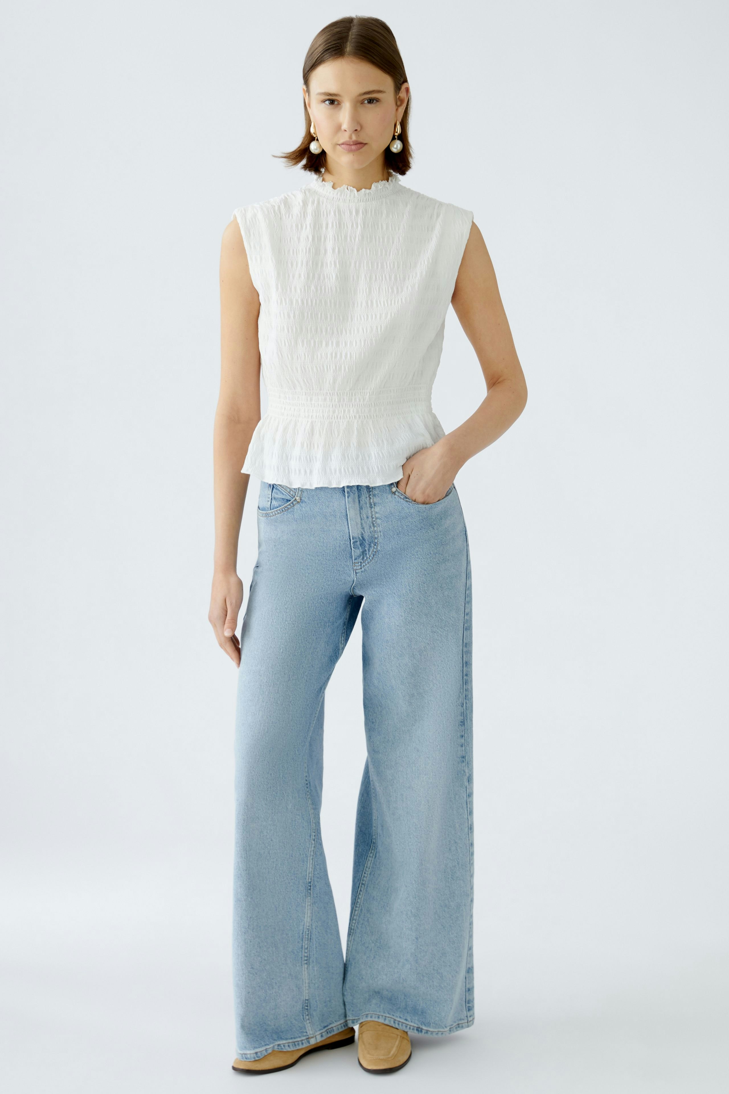 Stylish wide leg jeans: A woman in light blue wide leg jeans paired with a white top, exuding casual elegance.