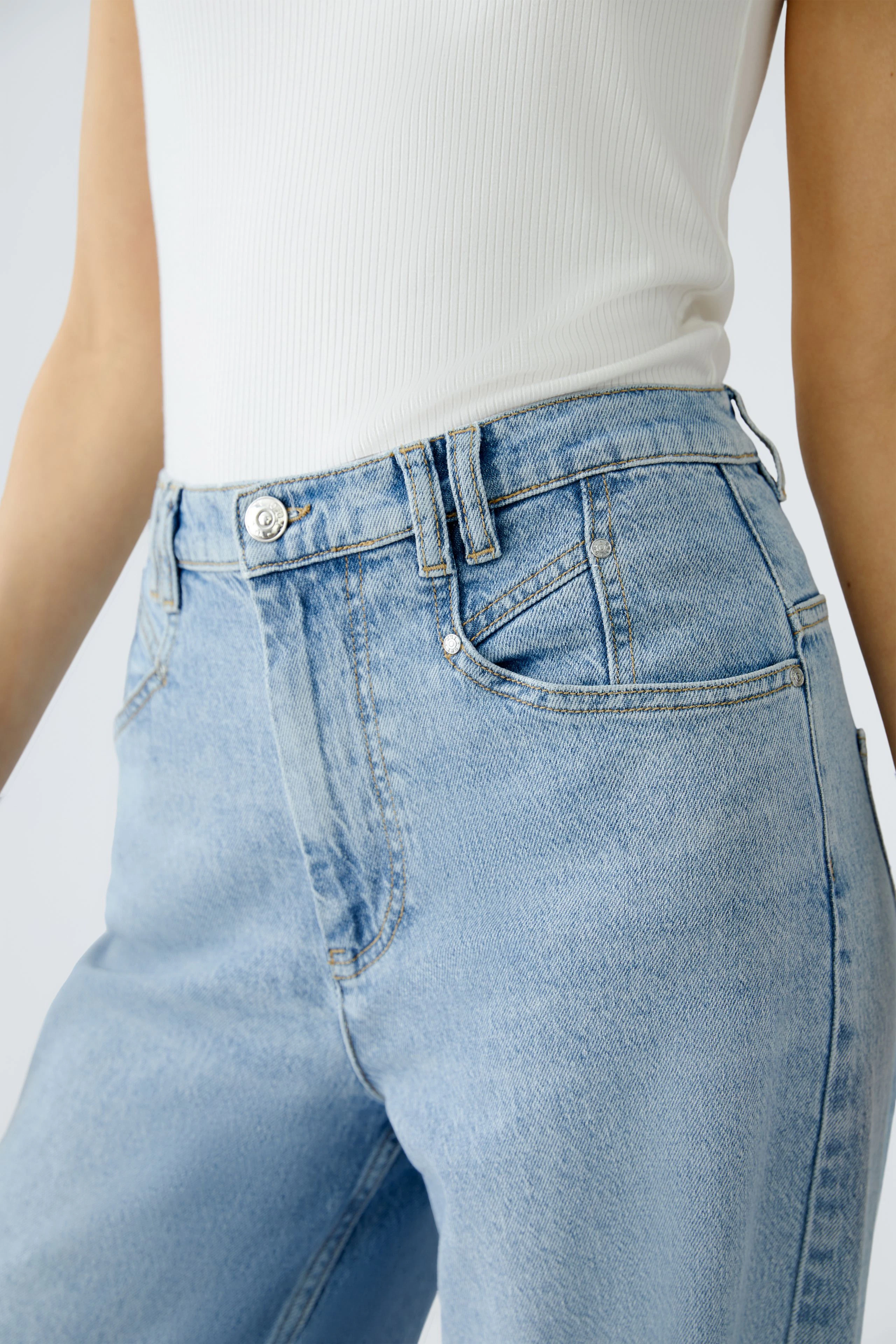 Stylish wide leg jeans: A woman showcases light blue jeans with a high waist and classic pockets.
