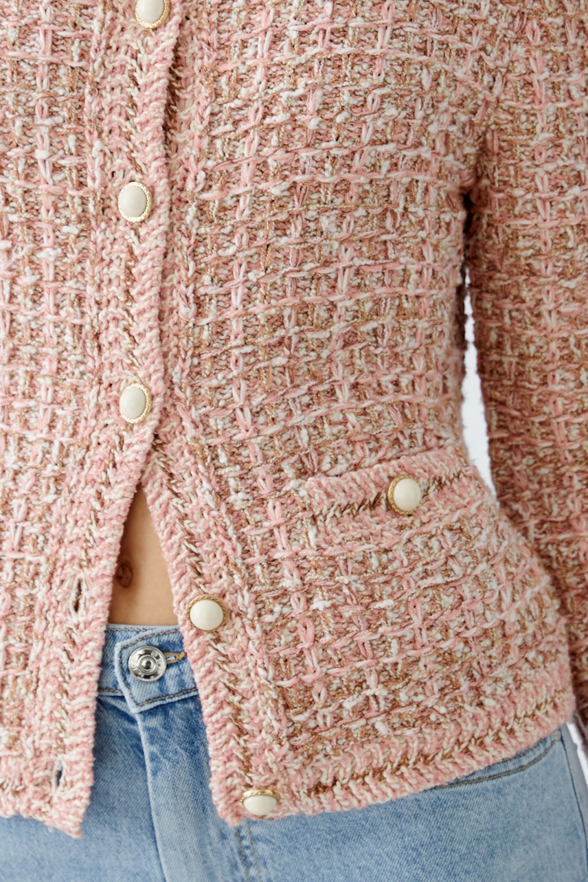 Stylish women's cardigan in soft pink with textured weave and button details.