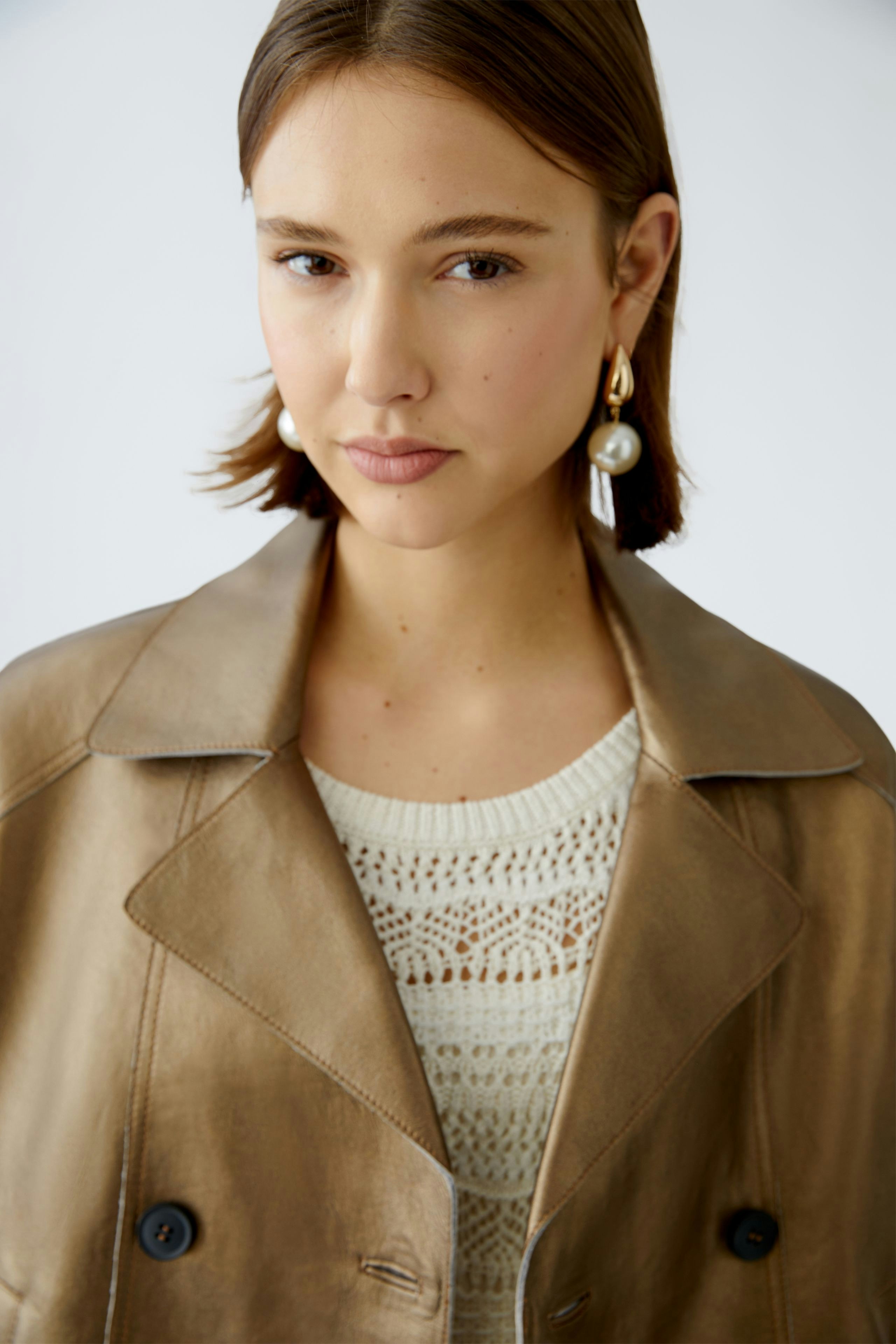 Stylish women's leather jacket: A woman showcases a chic, light brown leather jacket with a modern design.