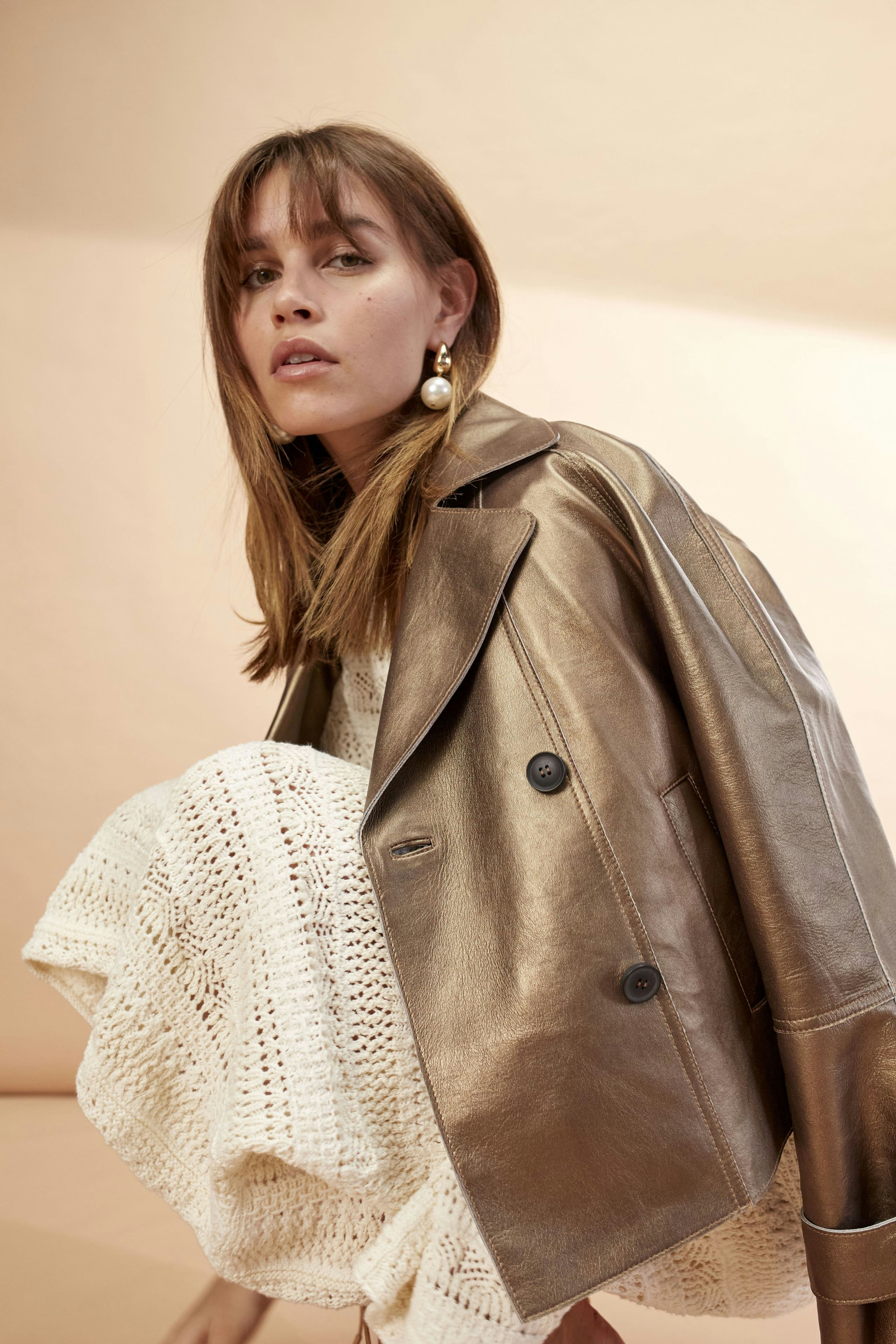 Stylish women's leather jacket: A woman in a chic metallic leather jacket, exuding confidence.