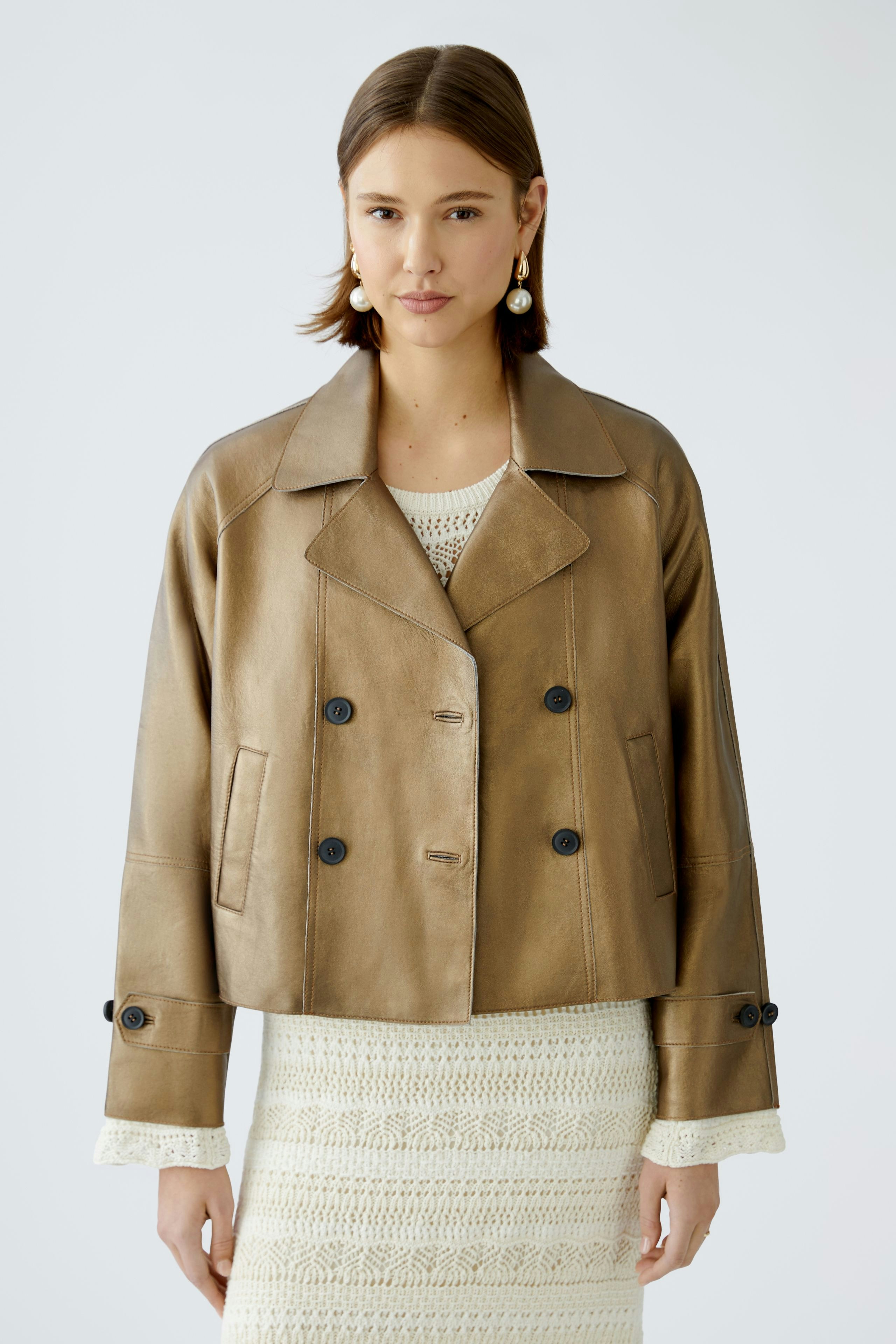 Stylish women's leather jacket: A woman in a cropped brown leather jacket with a classic collar.