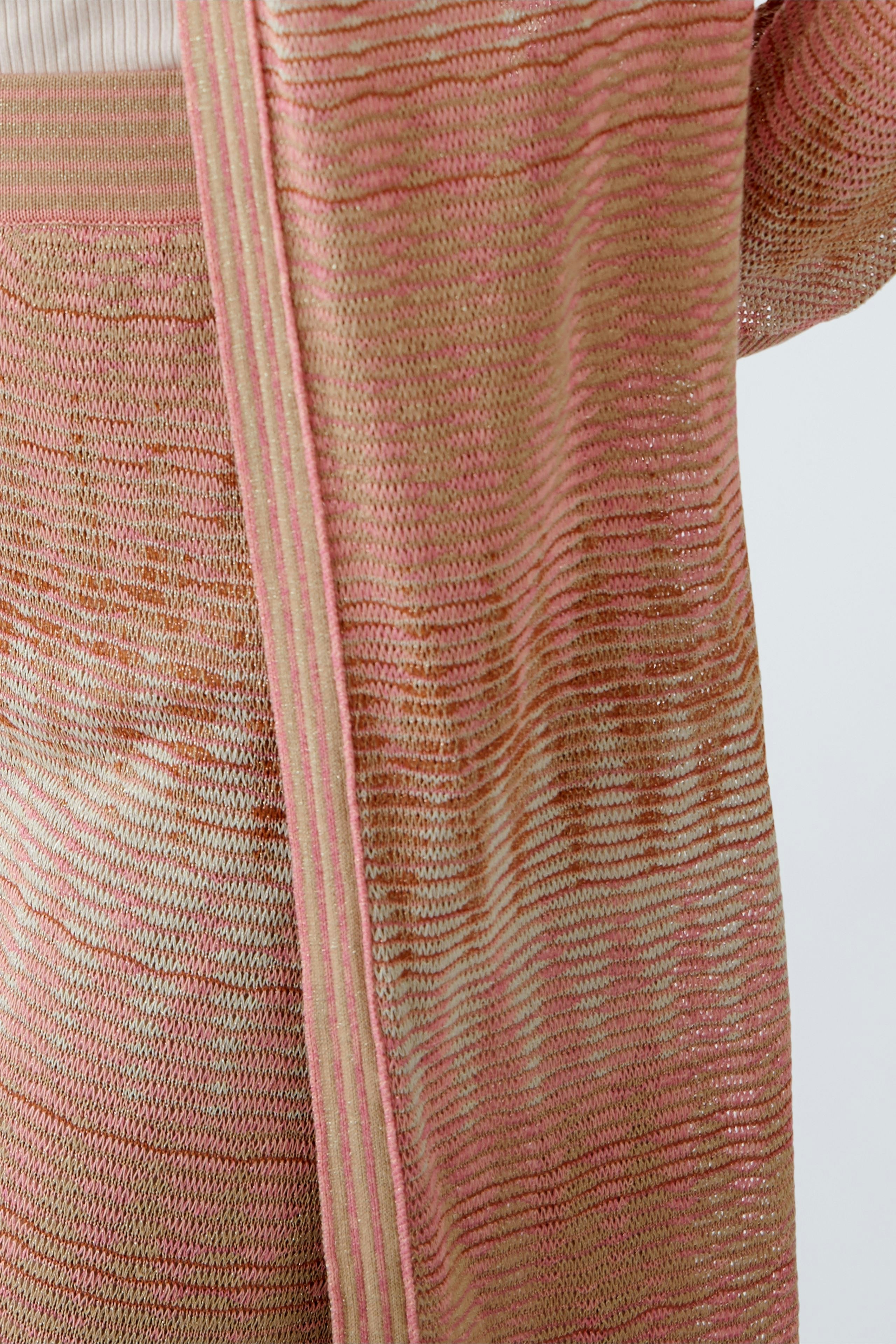 Stylish women's cardigan: A woman in a pink striped knit cardigan, perfect for layering.