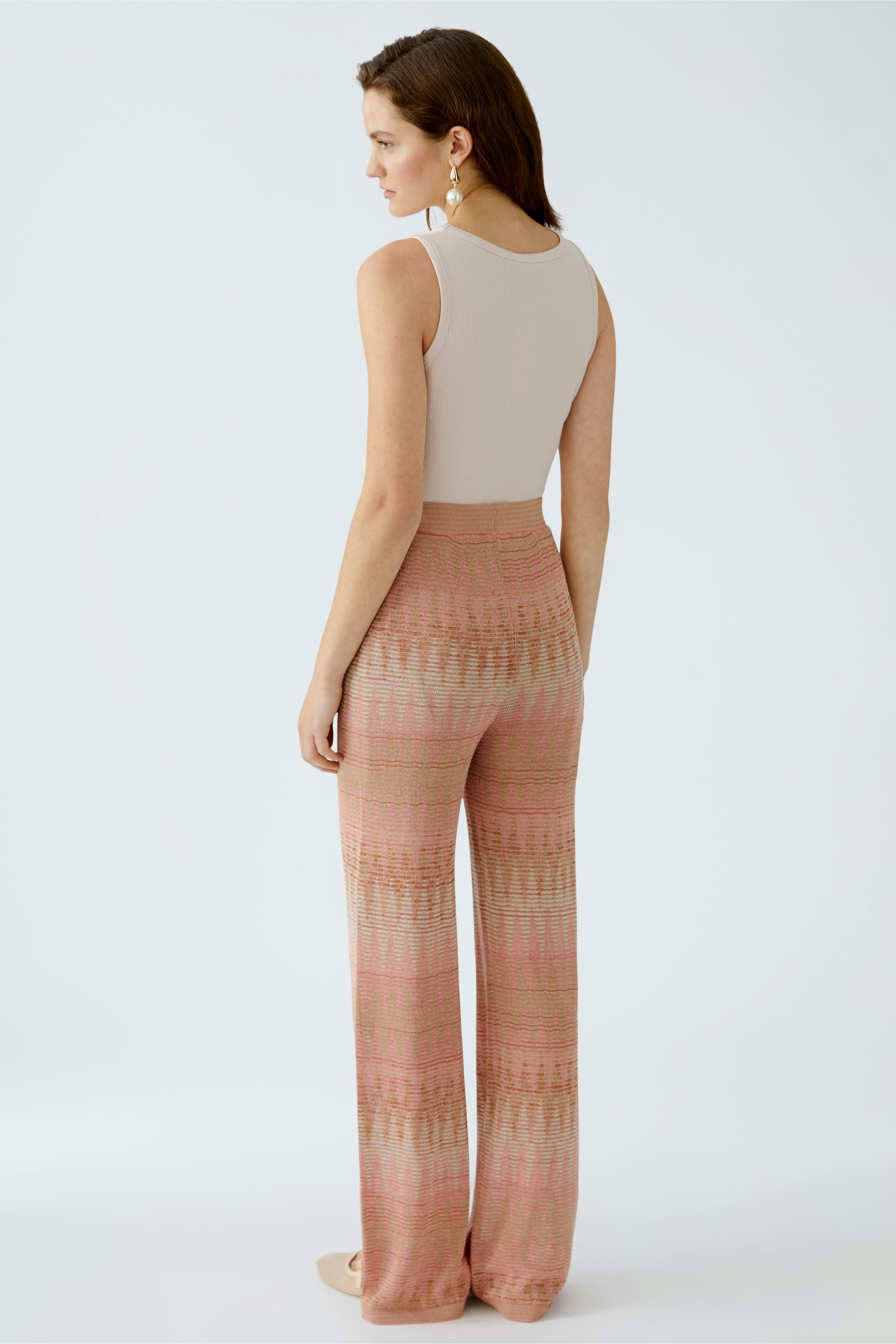 Damen-Strickhose: Frau von hinten in beiger Top und gemusterter, weicher Strickhose.